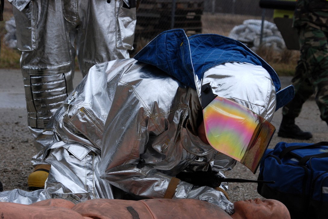 A 932nd Airlift Wing firefighter checks a simulated "patient" during a training drill at the Air Force Reserve Command unit near Belleville, Ill.  Self aid and buddy skills are constantly taught and stressed throughout a training year.  (U.S. Air Force photo/Tech. Sgt. Dan Oliver)