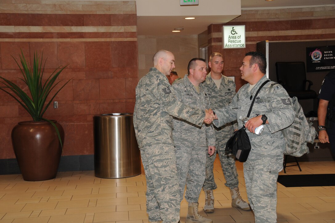 U.S. Air Force Tech. Sgt. Bryan Angst, assigned to the 161st Air Refueling Wing Security Forces Squadron, Phoenix Ariz., is greeted by Tech. Sgt Kyle Tolle and Master Sgts. Sonny Copeland and Brian Thomas as he returns home following a six month deployment to Kyrgyzstan in support of Operation Enduring Freedom on August 18, 2010. (U.S. Air Force photo by Master Sgt. Kelly Deitloff)