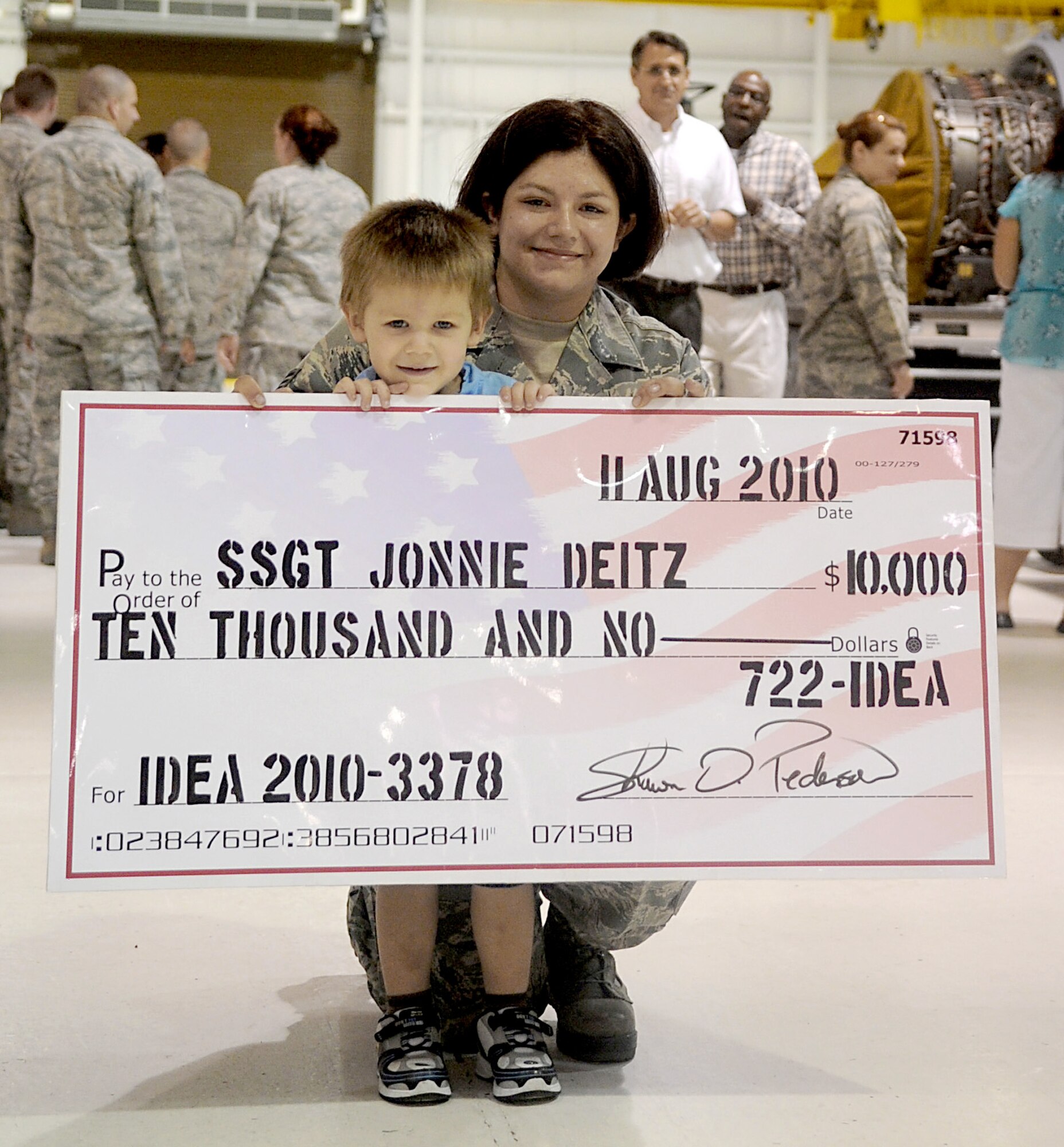 Staff Sgt. Jonnie Dietz poses with her son, Brian, after receiving a check for $10,000 from the Air Force Innovative Development Through Employee Awareness Program Aug. 12, 2010 at Seymour Johnson Air Force Base, N.C. The IDEA Program awards Airmen, who have smart proposals that lead to improvements or monetary savings, with payments based on the merits of their recommendation. Sergeant Deitz's idea could save the Air Force $359,000. Sergeant Dietz is a 4th Component Maintenance Squadron aerospace propulsion journeyman. (U.S. Air Force photo/Senior Airman Makenzie Lang)
