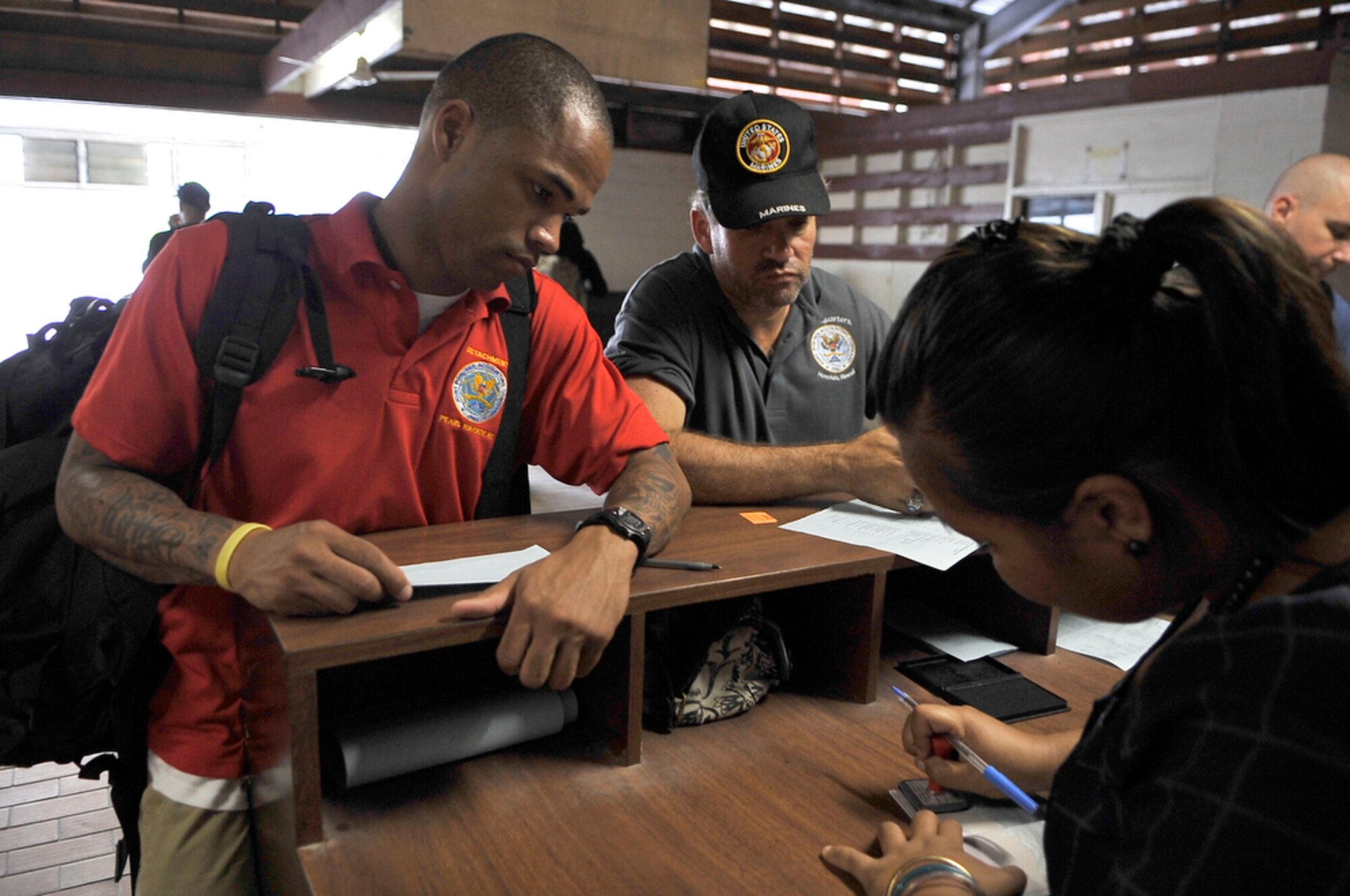 U.S. Army  Staff Sgt.Jordy Anthony (left) from the Joint POW/MIA Accounting Command and movie documenter Steven Barber get their passports validated at the customs desk upon arriving in Tarawa, Republic of Kiribati, on Aug 6, 2010. JPAC is recovering the remains of Marines from the WWII Battle of Tarawa where a total of 1,113 2nd Marine Division Marines died and 2,290 were wounded. (U.S.  Air Force photo/Tech Sgt. Cohen A. Young)