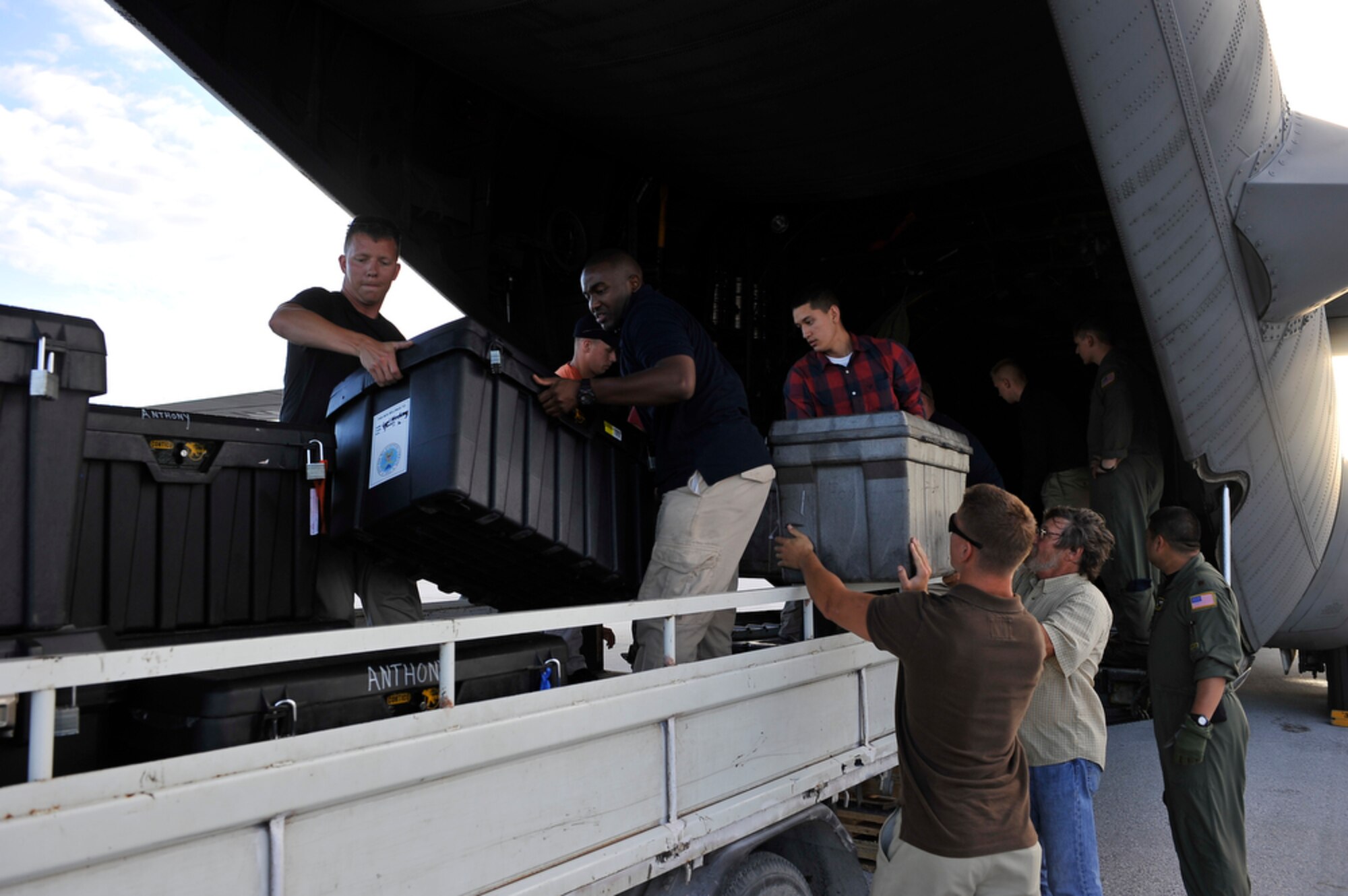 Members of the Joint POW/MIA Accounting Command unload their gear upon arriving  at Tarawa, Republic of Kiribati, on Aug 6, 2010 to recover the remains of Marines from the WWII Battle of Tarawa where a total of 6,000 men from U. S. and Japan lost their lives. (U.S.  Air Force photo/Tech Sgt. Cohen A. Young)