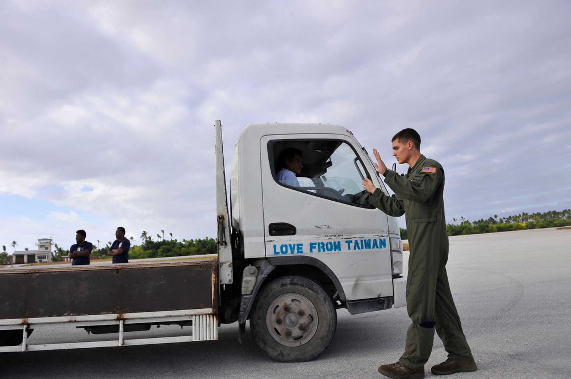 374th Airlift Wing loadmaster, Airman First Class Joseph Doria guides a driver as he backs the truck to a C-130 in order to unload equipment after arriving at Tarawa, Reupublic of Kiribati, on Aug. 6, 2010. Airman Doria's crew transported members of the Joint POW/MIA Accounting Command to Tarawa so they could begin recovering the reamains of 2nd Marine Division Marines from the Battle of Tarawa,which took place during WWII and is a mainstay of history for the U. S. Marines because it was their first amphibious assault. (U.S.  Air Force photo/Tech Sgt. Cohen A. Young)