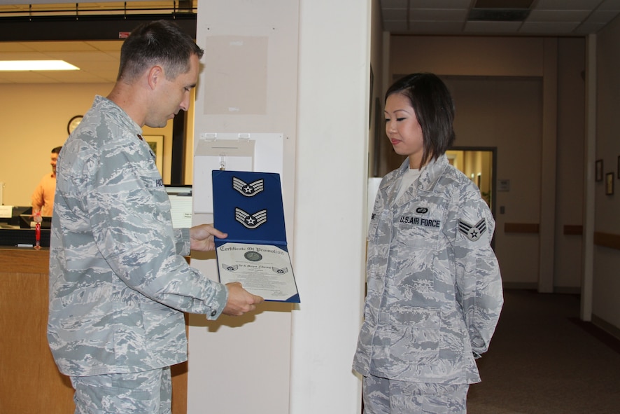 LAUGHLIN AIR FORCE BASE, Texas -- Major Shenen Hoefferle, 47th Comptroller Squadron commander, presents Senior Airman Boya Zheng with a certificate and stripes for her selection as a staff sergeant. Air Force Officials released the staff sergeant select list today. Airman Zheng and twenty-three other Laughlin Airmen have been selected. (U.S. Air Force photo by 2nd Lt. Kenneth Gilbert)
