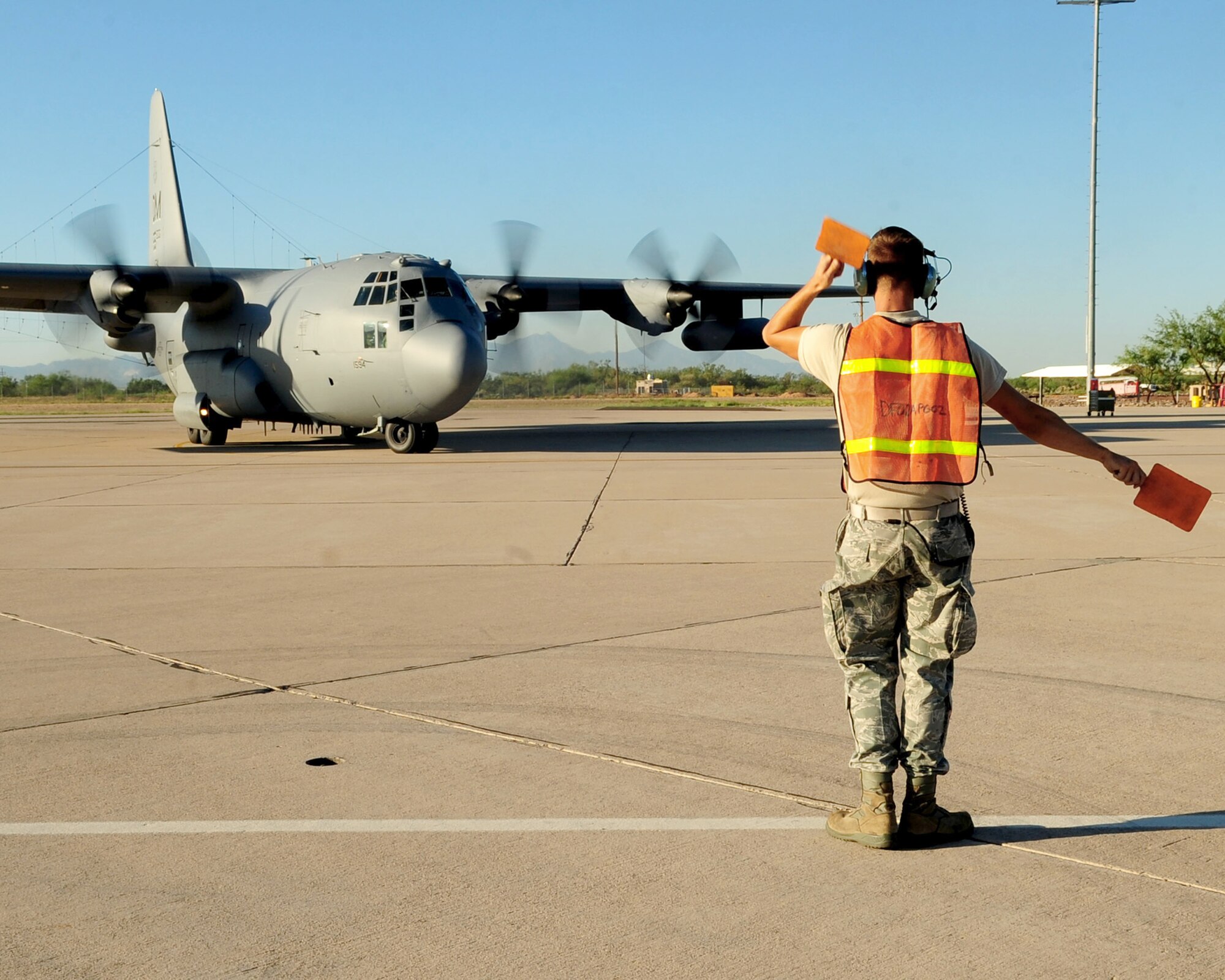 Airman 1st Class Marshall Dils guides an EC-130H Compass Call aircraft out of its parking spot and down the taxiway as it prepares to fly a training mission in support of Empire Challenge 10, a joint and coalition intelligence, surveillance and reconnaissance interoperability demonstration from July 26 to Aug. 13, 2010, staged primarily from Fort Huachuca, Ariz. Airman Dils is a member of the 755th Aircraft Maintenance Squadron. (U.S. Air Force photo/Airman 1st Class Jerilyn Quintanilla)