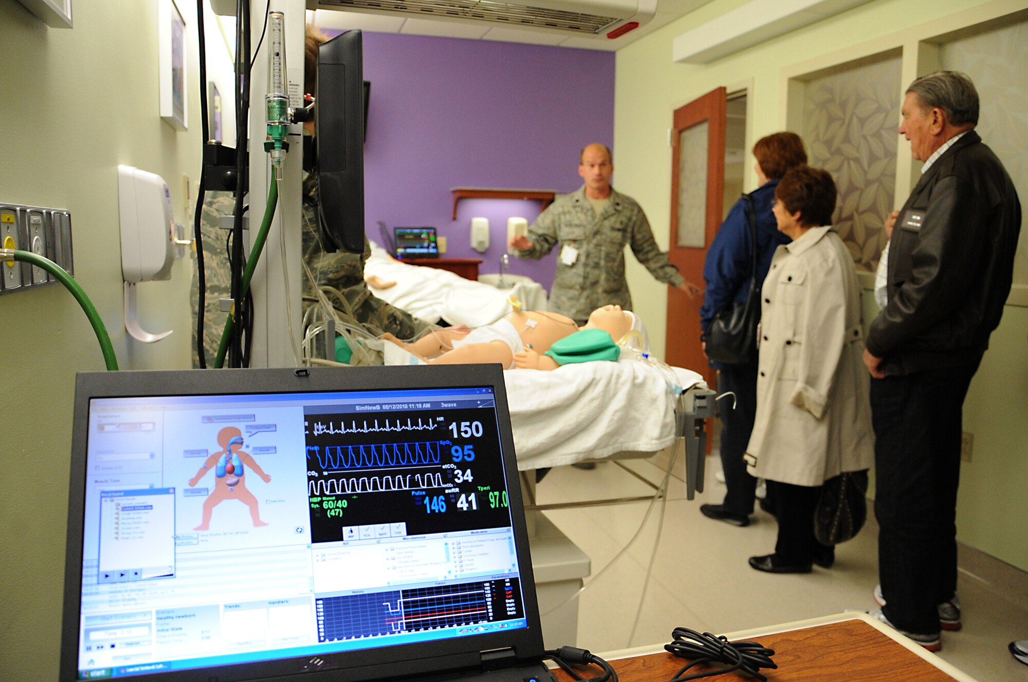 JOINT BASE ELMENDORF-RICHARDSON, Alaska -- Lt. Col. Ryan Shercliffe demonstrates and describes how computer controlled patient simulators are used during the Chief of Staff civic leader tour Aug.12. The operator controls a wide range of physiologic parameters such as the newborn's breathing, pulses, heart/lung sounds, movements, vocalizations and skin color. The operator's computer shows a graphic display of these newborn's parameters. Colonel Shercliffe is the director of the clinical simulation center with the 673d Medical Group. (Air Force photo by Senior Airman Cynthia Spalding)