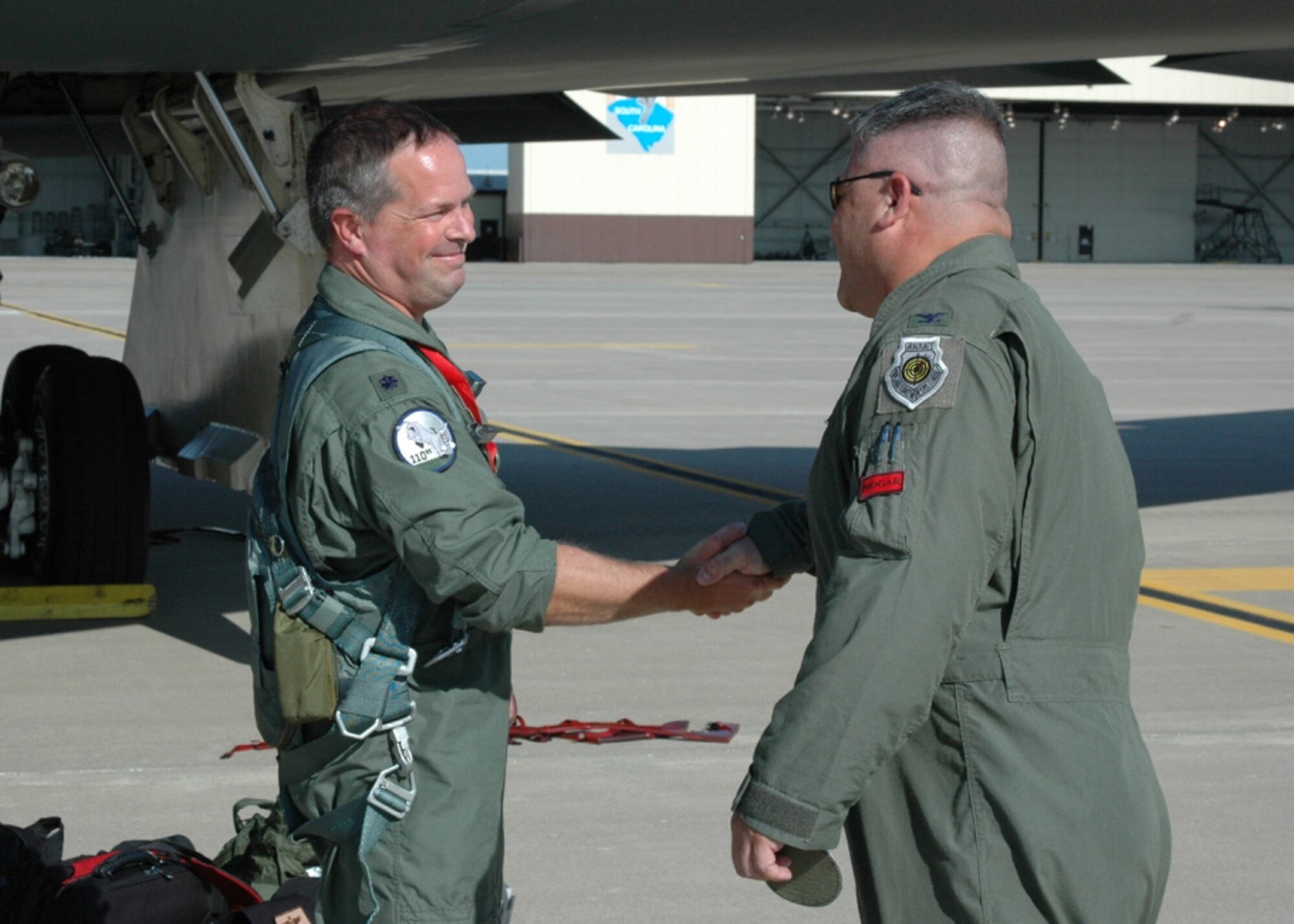 Lt. Col. Ken "Willie B" Eaves, 131st Operations Group commander, congratulates Lt. Col. Michael “Farmer” Pyburn on accomplishing 1000 B-2 flying hours at Whiteman AFB, Mo, August 15.  Pyburn joins an elite group of 131st Bomb Wing Missouri Air National Guard B-2 pilots: Lt. Col. Michael Means who achieved this milestone almost three years ago while on active duty; Lt. Col. Rhett Binger, June 2009;     Maj. Jared Kennish, Oct.2009; and  Maj. John Avery, March 2010.  (Air Force Photo by Technical Sgt. Chris Boehlein. RELEASED)