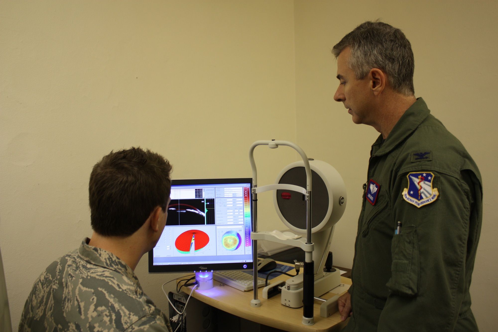 Col John Gooch, Chief Aerospace Opthamology, reviews the findings of the pentacam exam during a Aerospace medicine consulation with Capt. Ryan Brewer.   The pentacam is a corneal imager that is used with pilot who have undergone corrective surgery.  Photo By: Amy Velasquez