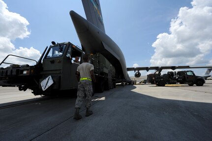 Senior Airman Marvin Richardson, right, keeps a watchful eye on loading operations as Airman 1st Class David May backs an aircraft loader into position at the rear of a C-17 bound for Afghanistan Aug. 18, 2010, at Joint Base Charleston, S.C. The Airmen are members of the 437th Aerial Port Squadron and were assigned to take on the second load operation in series of floating bridge shipments to aid deployed U.S. forces in crossing Afghanistan waterways. (U.S. Air Force photo/Airman 1st Class Lauren Main)