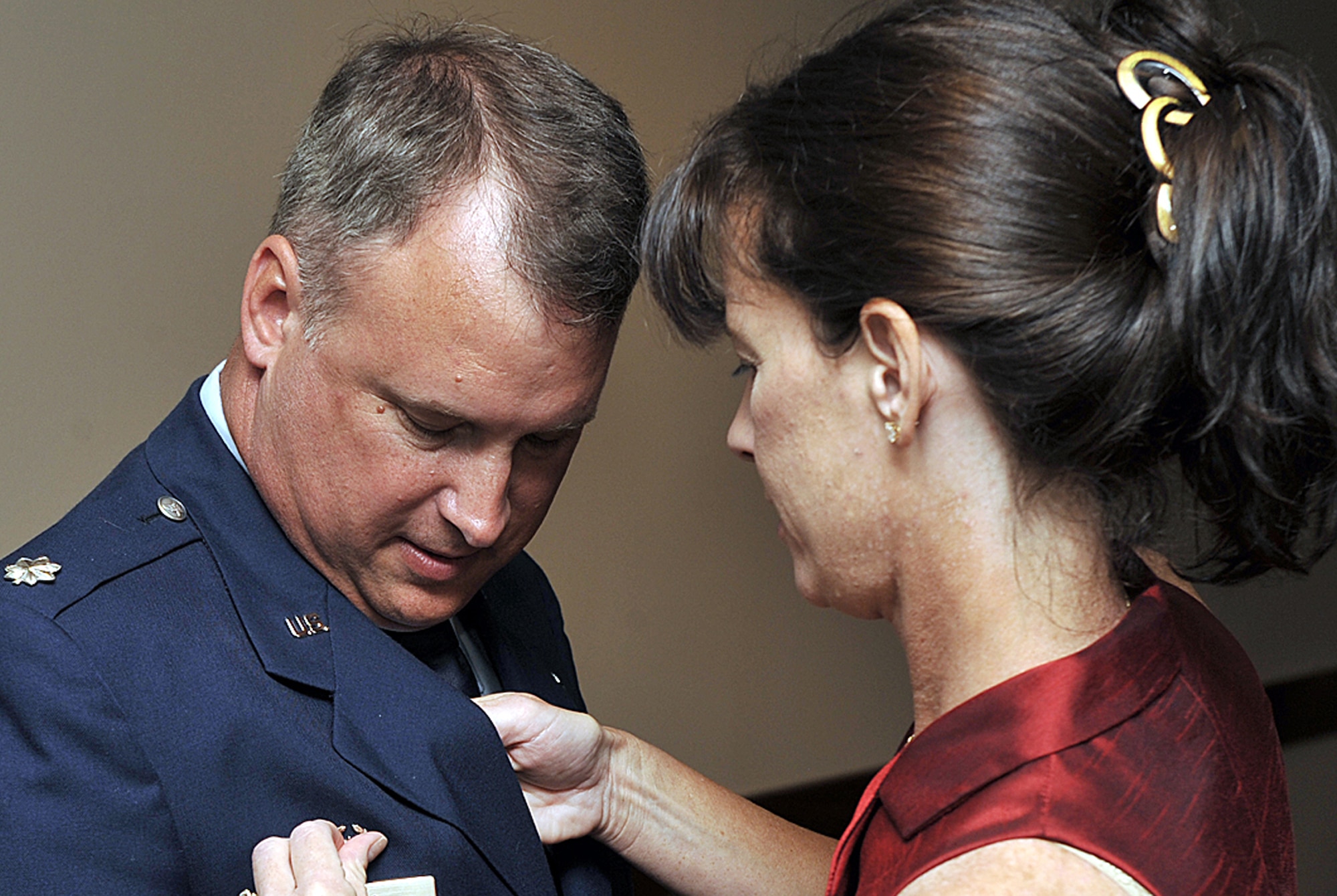 Lt. Col. Steven Foss receives his wife's assistance in pinning on his squadron commander badge Aug. 8 after he assumed command of the 731st Airlift Squadron at Peterson Air Force Base, Colo. Colonel Foss, an Air Force Reserve C-130 navigator, took command of the squadron from outgoing commander, Col. Courtney Arnold. As commander of the airlift squadron, Colonel Foss is responsible for the readiness of the dozens of aircrews who fly 12, C-130H3 Hercules tactical aircraft, which are assigned to the 302nd Airlift Wing. Colonel Foss is a master navigator with more than 4,500 flight hours. (U.S. Air Force photo/Larry Hulst)