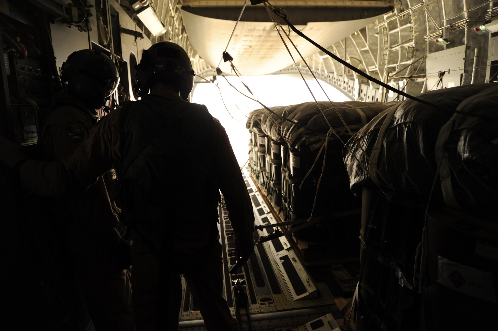 1st Lt. Daniel Hartung and Staff Sgt. Hardia Madden watch as bundles of JP-8 fuel begin to exit a C-17 Globemaster III during an airdrop mission Aug. 13, 2010, over a drop zone in Southwest Asia. Lieutenant Hartung and Sergeant Madden are with the 816th Expeditionary Airlift Squadron. (U.S. Air Force photo/Staff Sgt. Tim Jenkins)