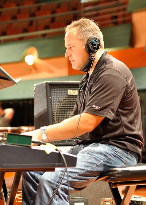 Master Sergeant Darrin Dziergowski plays piano during the third day of the concert band recording session.  