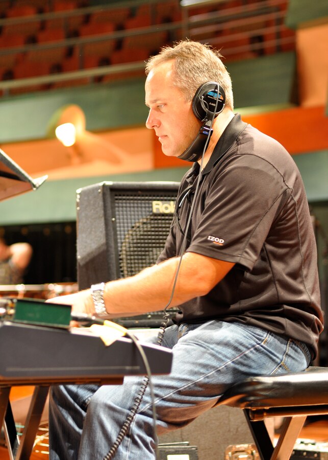Master Sergeant Darrin Dziergowski plays piano during the third day of the concert band recording session.  