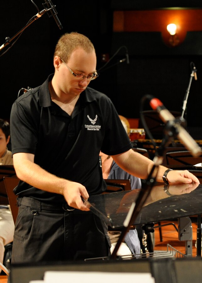Airman First Class Brian Lumpkin makes last minute adjustments to the conductor's stand before the recording session begins on August 11, 2010.