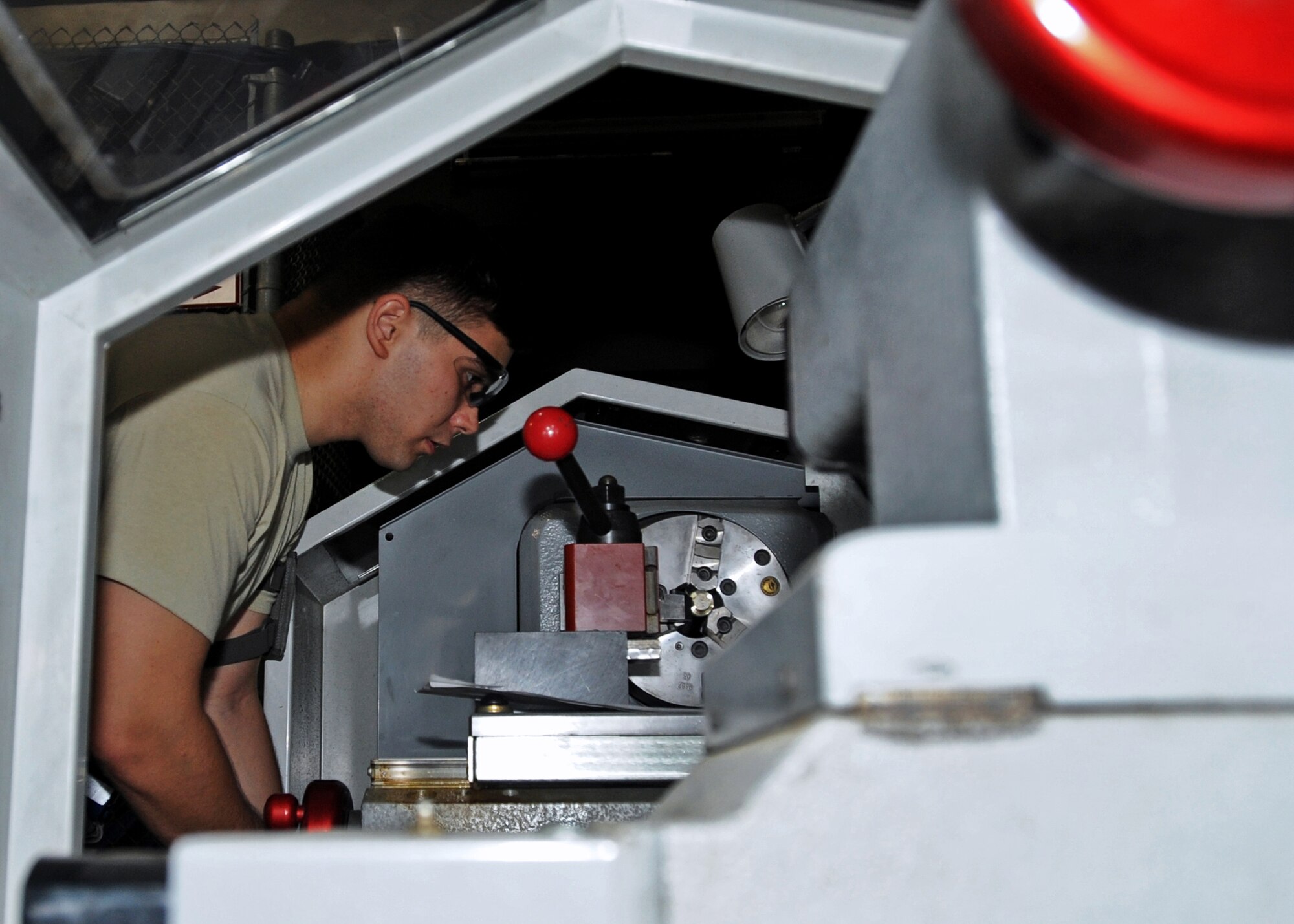 SOUTHWEST ASIA - Airman 1st Class Phillip Jackson, an aircraft metals technology journeyman from the 386th Expeditionary Maintenance Squadron’s Combat Metals Flight, cuts a bushing for an engine hoist fixture here Aug. 17, 2010. The flight is capable of cutting a piece of metal down to a thousandth of an inch, the thickness of one-third of a strand of human hair. (U.S. Air Force photo by Senior Airman Laura Turner)