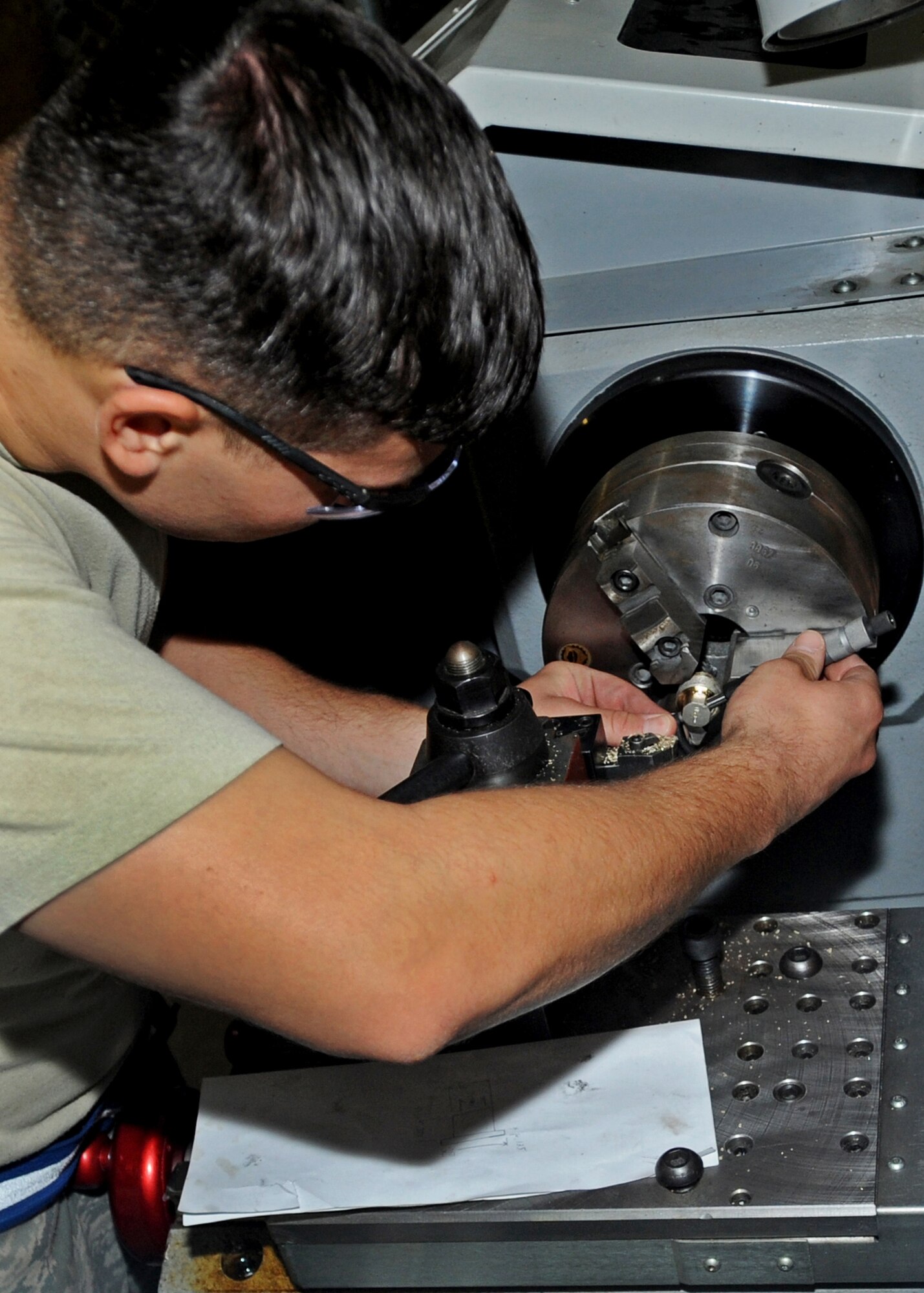 SOUTHWEST ASIA - Airman 1st Class Phillip Jackson, an aircraft metals technology journeyman from the 386th Expeditionary Maintenance Squadron, cuts a bushing for an engine hoist fixture here Aug. 17, 2010. The unit fabricates aircraft parts from scratch to keep the aircraft flying across the theater of operations. (U.S. Air Force photo by Senior Airman Laura Turner)