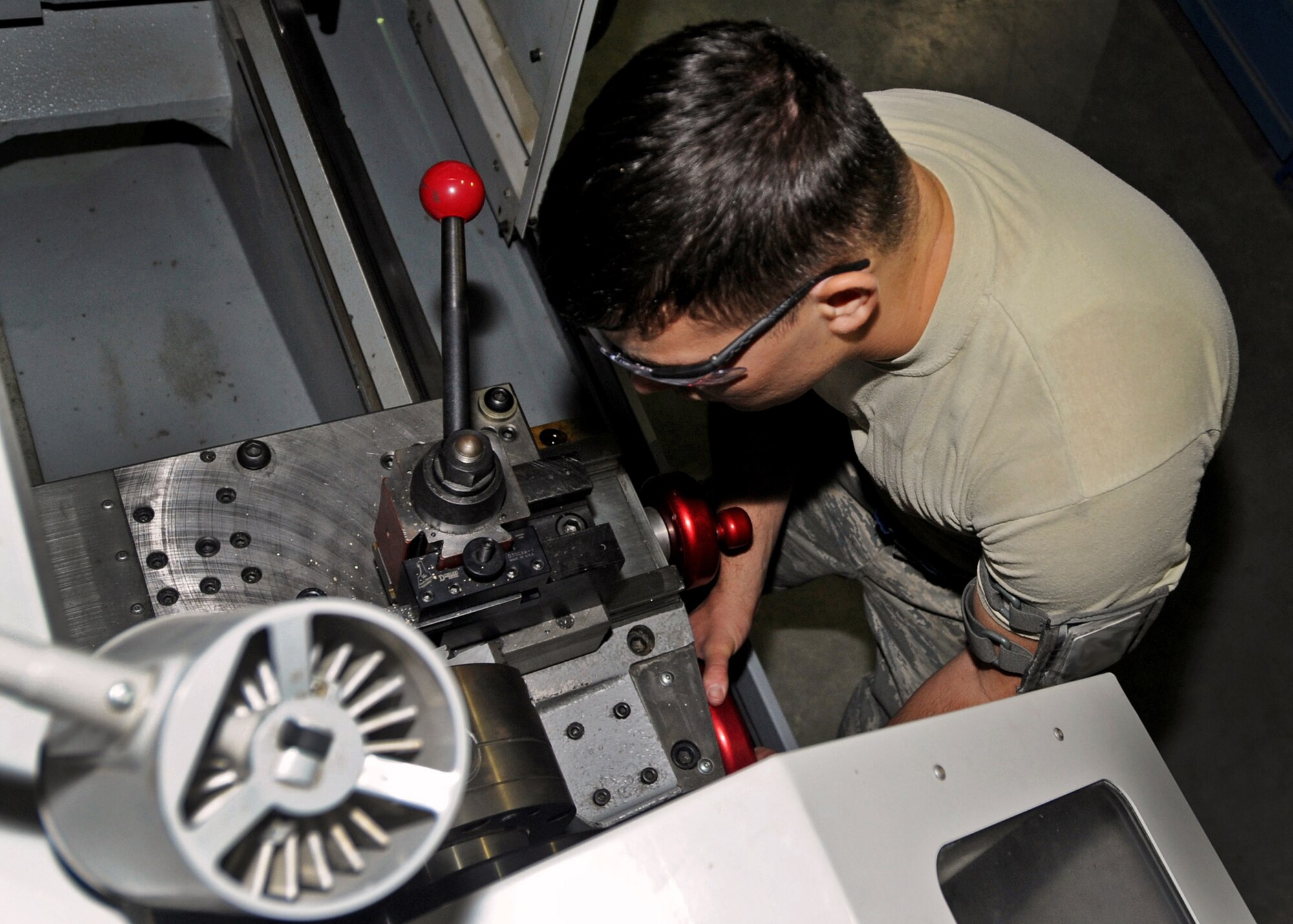 SOUTHWEST ASIA - Airman 1st Class Phillip Jackson, an aircraft metals technology journeyman from the 386th Expeditionary Maintenance Squadron, cuts a bushing for an engine hoist fixture here Aug. 17, 2010. Combat metals technicians use a variety of machines and measuring tools to fabricate new aircraft components. (U.S. Air Force photo by Senior Airman Laura Turner)