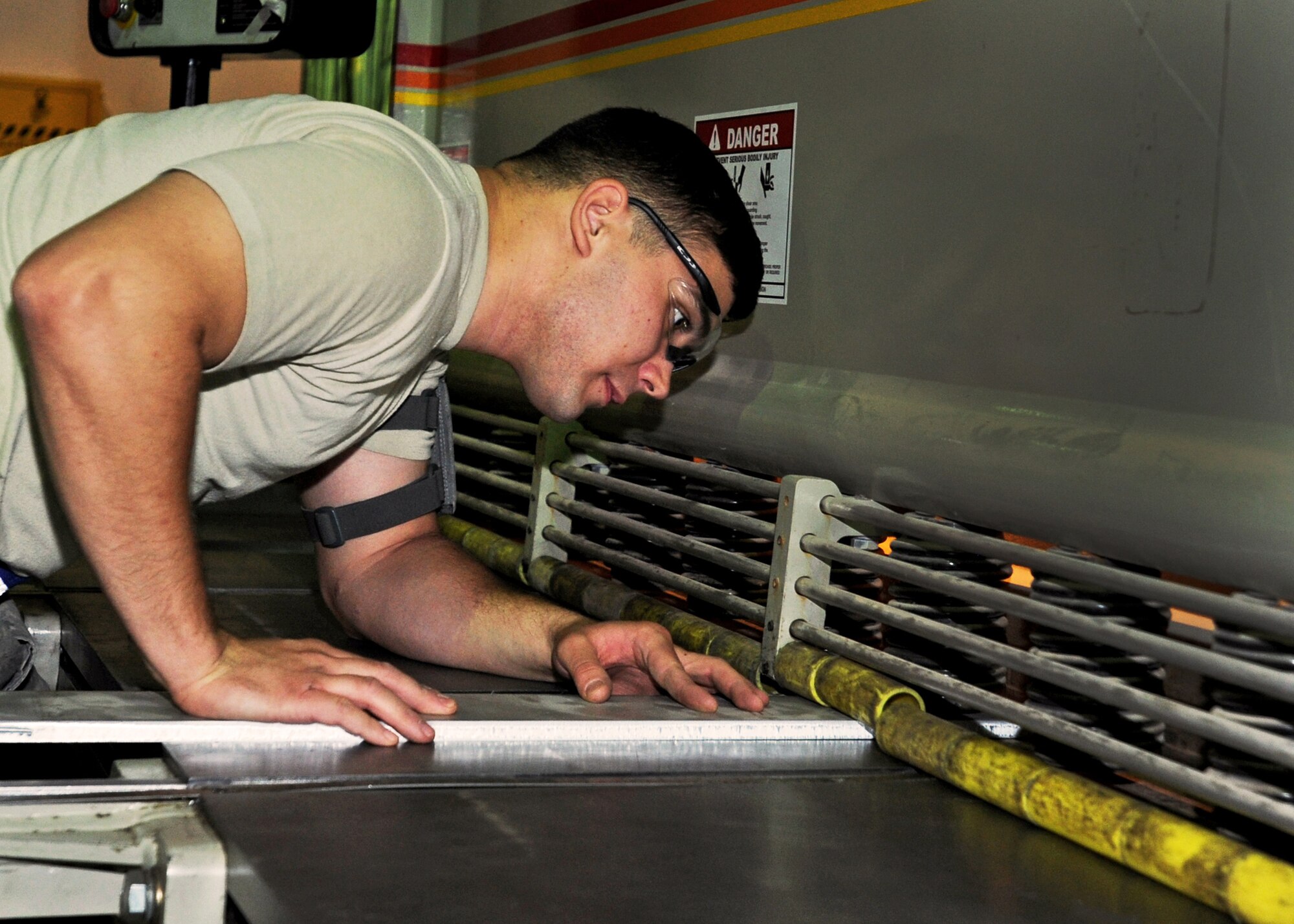 SOUTHWEST ASIA - Airman 1st Class Phillip Jackson, an aircraft metals technology journeyman from the 386th Expeditionary Maintenance Squadron, sheers a piece of metal to fabricate a C-12 rudder alignment fixture here Aug. 17, 2010. The combat metals flight answers the need beyond the 386th Air Expeditionary Wing, creating essential aircraft components in as little time as possible for the host-nation partner, U.S. Army, and sometimes to the bases in Iraq and Afghanistan. (U.S. Air Force photo by Senior Airman Laura Turner)