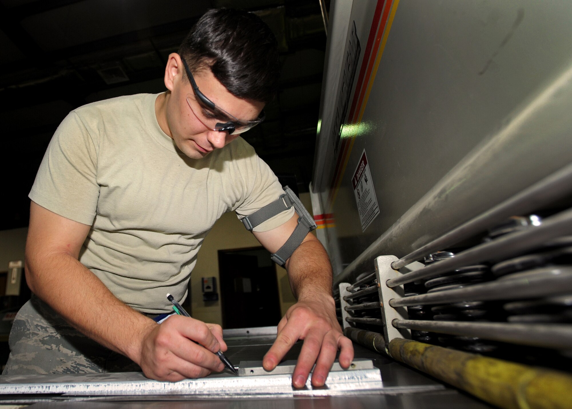 SOUTHWEST ASIA - Airman 1st Class Phillip Jackson, an aircraft metals technology journeyman from the 386th Expeditionary Maintenance Squadron’s Combat Metals Flight, marks where to cut a piece of metal in the process of making a C-12 rudder alignment fixture here Aug. 17, 2010. The flight can fabricate or repair metal parts for aircraft by welding, cutting, bending, riveting and shaping components from a single piece of metal. (U.S. Air Force photo by Senior Airman Laura Turner)