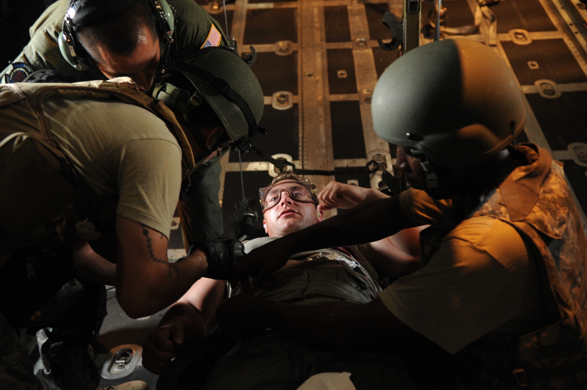 Students attending the Air Force Special Operations Command Casualty Evacuation course prepare to insert an IV into a simulated patient onboard an MC-130 Aug. 9 during a simulated casualty evacuation. During the two week CASEVAC Course, students were placed in stressful situations to help them apply their skill sets in austere stressful environments, like the back of a MC-130 during low level flight. (DoD photo by Airman Caitlin O'Neil-Mckeown)