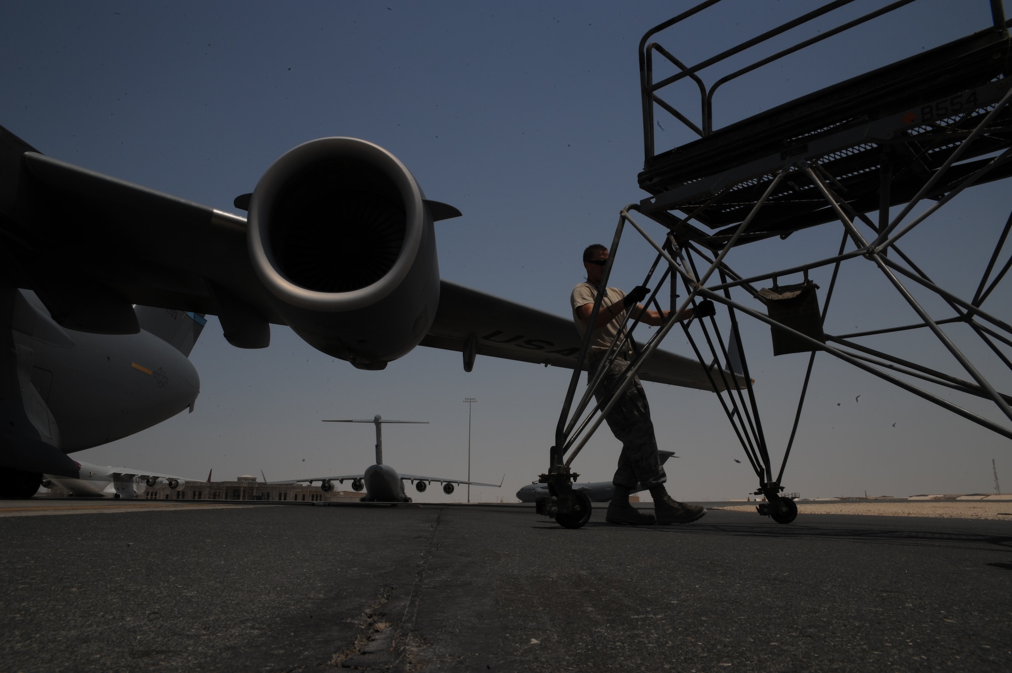 Technical Sergeant Joseph Pierson moves a stand prior to performing intake and exhaust checks on a C-17 Globemaster III at an undisclosed location in Southwest Asia August 13. Sergeant Pierson is a jet engine mechanic with the 8th Expeditionary Aircraft Maintenance Squadron and is deployed from Travis AFB, Calif. (U.S. Air Force photo/Senior Airman Katie Gieratz)  [RELEASED]