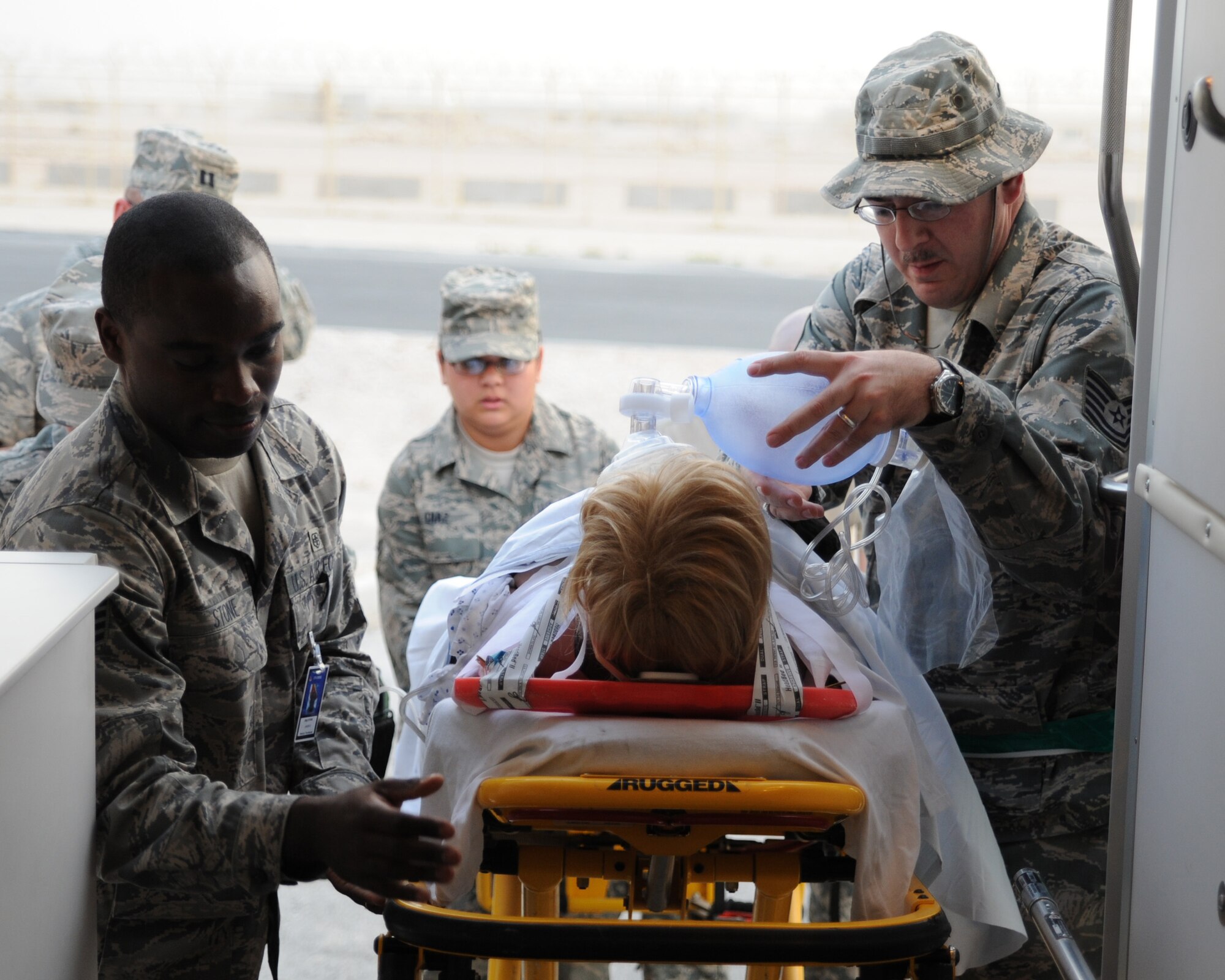 Staff Sergeant Jason Stone and Technical Sergeant James Pounds load a patient onto an ambulance during training at an undisclosed location in Southwest Asia July 28. Sergeant Stone and Sergeant Pounds are aerospace medical technicians with the 379th Expeditionary Medical Operations flight. Sergeant Stone is deployed from Lackland AFB, TX and Sergeant Pounds is deployed from Keesler AFB, Miss. (U.S. Air Force photo/Senior Airman Katie Gieratz)  