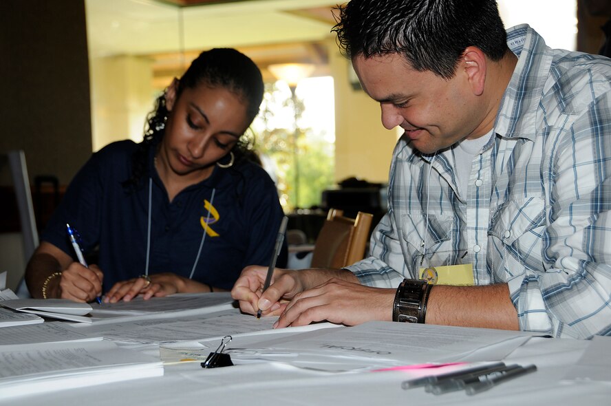 Capt. Amanda Hacman and Senior Airman Norlys Oria, 482nd Fighter Wing, Homestead ARB, Fla., help process orders for the 130 Airmen and their families attending the Yellow Ribbon Event at the Shades of Green Resort located in Disney World on Aug 16. Airmen and their families were given an opportunity to receive  information about programs and services available to them while also attending  various classes and sessions that dealt with issues facing deployed Airmen. (U.S. Air Force Photo/Senior Airman Lou Burton)