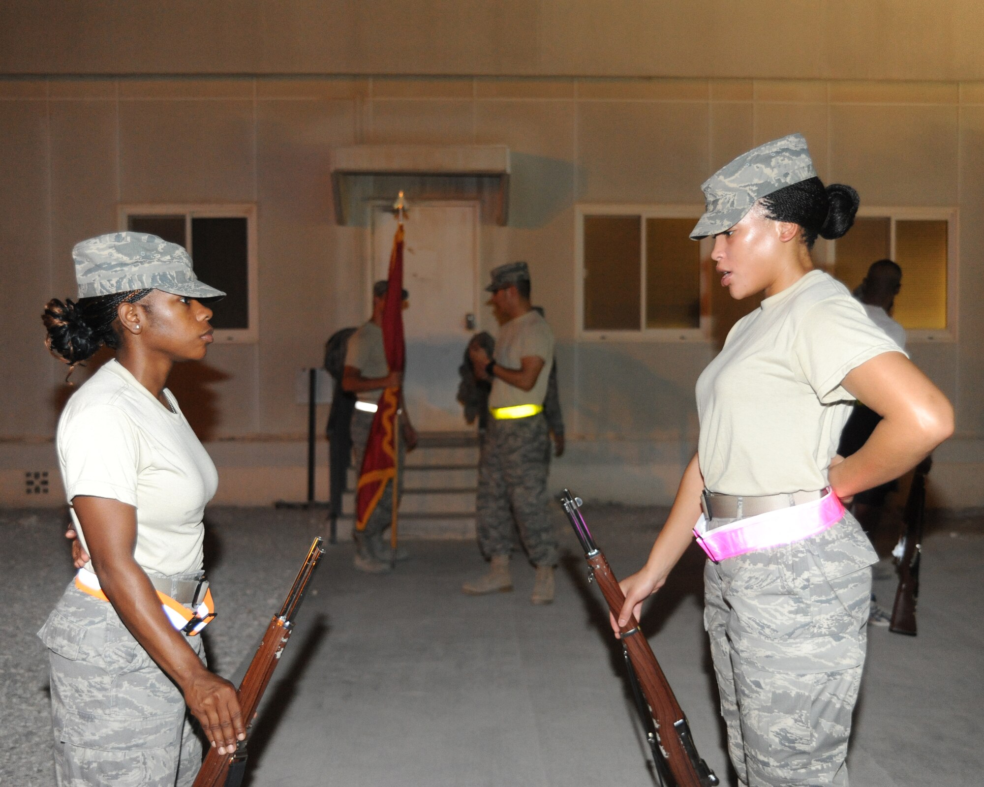 Senior Airman Chandra Bryant trains Airman 1st Class Shaniqua Anderson on colors during honor guard practice at an undisclosed location in Southwest Asia, August 3. Airman Bryant is an aviation resource manager with the 379th Expeditionary Operations Support Squadron deployed from Tyndall AFB, FL and Airman Anderson is a material management specialist with the 379th Expeditionary Logistics Readiness Squadron and is deployed from Nellis AFB, NV. (U.S. Air Force photo/Senior Airman Katie Gieratz)