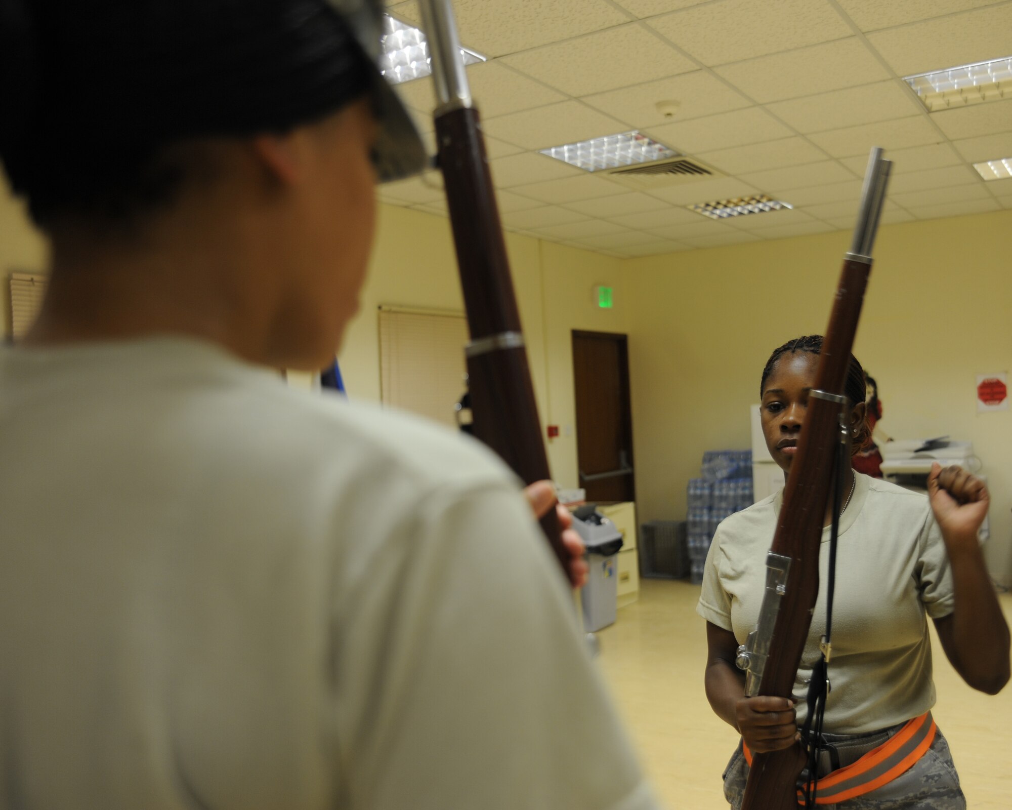 Senior Airman Chandra Bryant trains Airman 1st Class Shaniqua Anderson on colors during honor guard practice at an undisclosed location in Southwest Asia, August 3. Airman Bryant is an aviation resource manager with the 379th Expeditionary Operations Support Squadron deployed from Tyndall AFB, FL and Airman Anderson is a material management specialist with the 379th Expeditionary Logistics Readiness Squadron and is deployed from Nellis AFB, NV. (U.S. Air Force photo/Senior Airman Katie Gieratz)