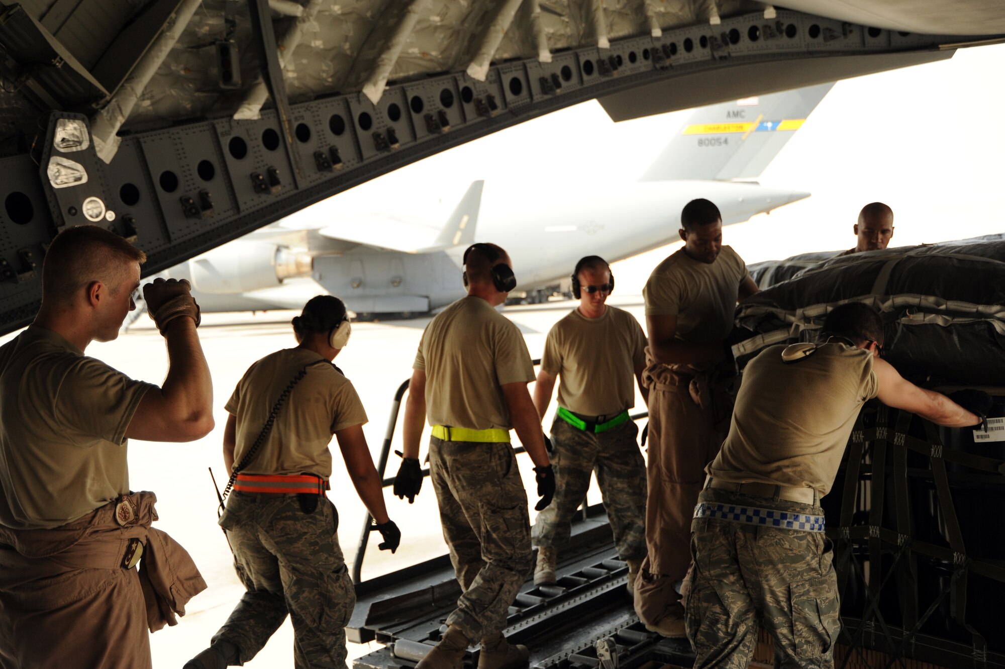 Airmen pull bundles of JP-8 fuel onto a C-17 Globemaster III at an undisclosed location in Southwest Asia prior to an airdrop mission Aug. 13. (U.S. Air Force photo/Staff Sgt. Tim Jenkins)