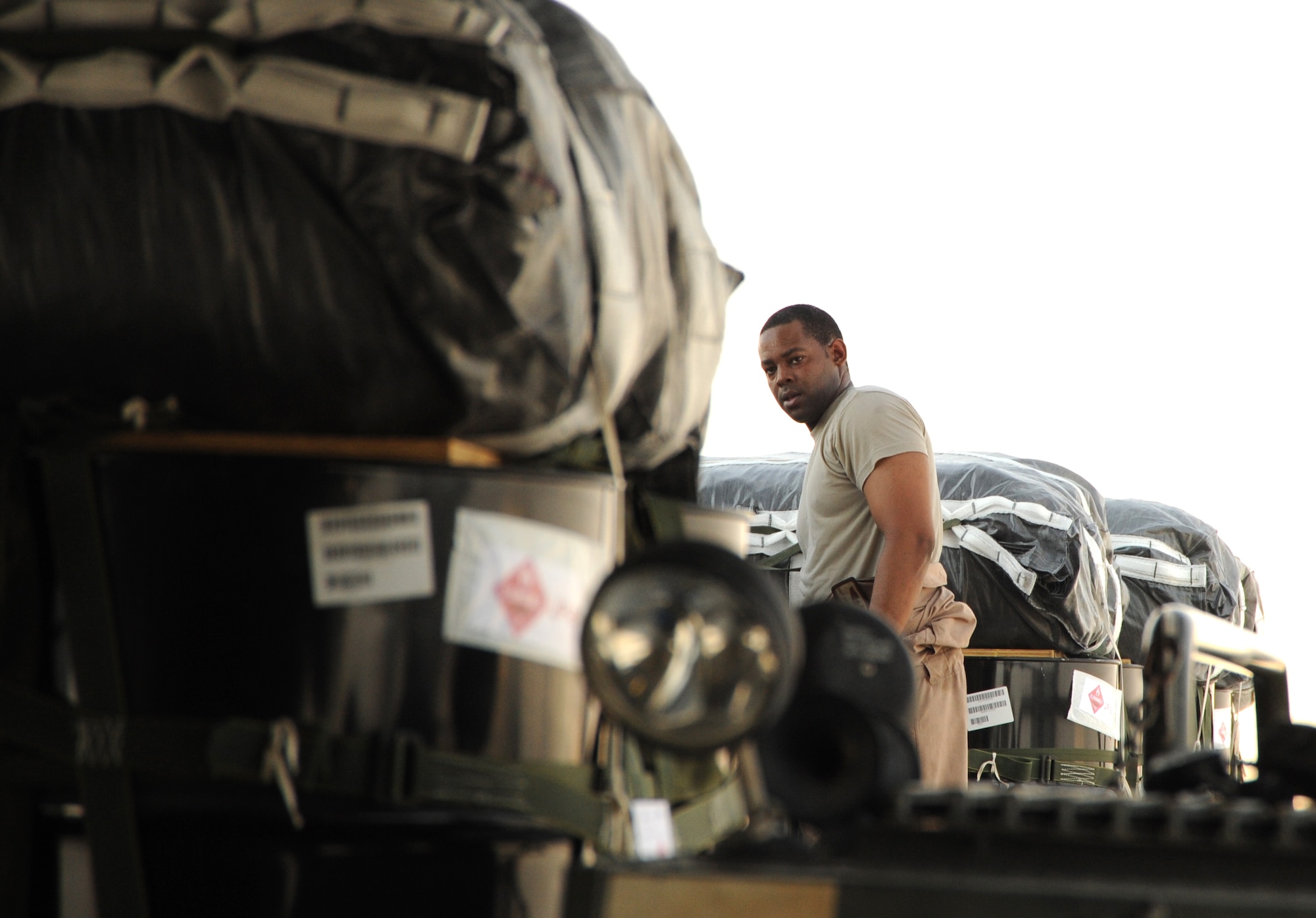 Staff Sgt. Hardia Madden, 816th Expeditionary Airlift Squadron aircraft loadmaster, loads bundles of JP-8 fuel onto a C-17 Globemaster III at an undisclosed location in Southwest Asia prior to an airdrop mission Aug. 13. The drop consisted of 40 bundles, each weighing a total of 1,830 pounds. (U.S. Air Force photo/Staff Sgt. Tim Jenkins)