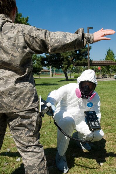 KUNSAN AIR BASE, Republic of Korea -- Tech. Sgt. Mathew Hardy, 8th Medical Operations Squadron Industrial Hygiene NCO, uses a ADM-300 to check for alpha radiation during decontamination on Senior Airman Sarah Carr, 8th MDOS bioenvironmental technician, Aug. 19.  The ADM-300 is used to detect alpha, beta, and gamma radiation wherever present.  (U.S. Air Force photo/Staff Sgt. Jonathan Pomeroy)
