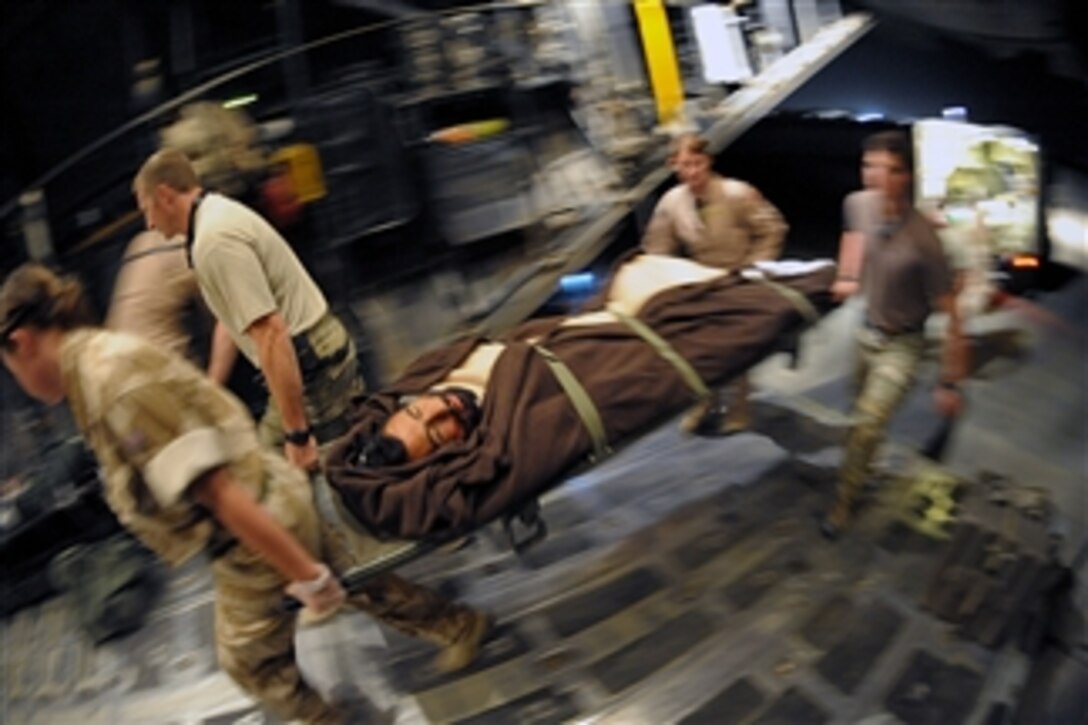 Coalition forces carry an injured Afghan man onto a U.S. Air Force HC-130P/N King aircraft in Helmand province, Afghanistan, on Aug. 16, 2010.  The patient, who suffered a fractured femur in a motorcycle accident, is being transported to a facility to receive advanced medical care.  