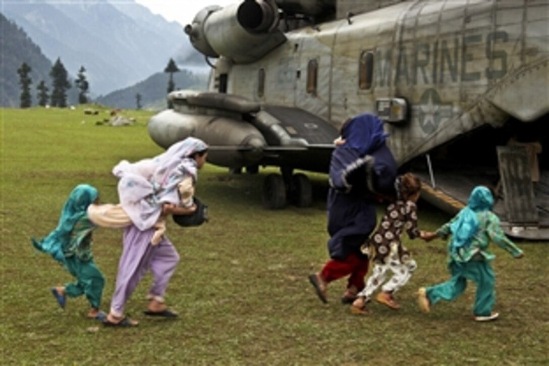 Pakistani women and children board a U.S. Marine CH-53E Super Stallion helicopter during humanitarian relief efforts for flood victims in Khyber-Pakhtunkhwa province, Pakistan, Aug. 17, 2010. The Marines are assigned to the 15th Marine Expeditionary Unit.