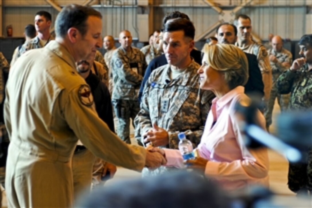 U.S. Air Force Brig. Gen. Michael Boera shakes hands with Katie Couric, news anchor with CBS Evening News, in the joint air fighter hangar on the Afghan Air Force base in Kabul, Afghanistan, Aug. 18, 2010. Couric visited the base to interview both Boera, commanding general of the Combined Air Power Transition Force, and U.S. Army Lt. Gen. William B. Caldwell, center, commanding general, NATO Training Mission, Combined Security Transition Command Afghanistan.