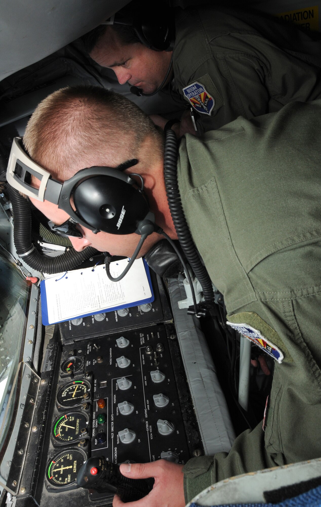 U.S. Air Force Senior Master Sgt. Bill Garrett, 161st Operations Group boom operator, instructs Staff Sgt. Kyle Davidson as he performs checklist steps during an aerial refueling mission over the Pacific Ocean, August 18, 2010. The 161st Air Refueling Wing KC-135s refueled three Hawaii Air National Guard F-15s on their way to Nellis Air Force Base. (U.S. Air Force Photo by Senior Airman Nicole Enos)