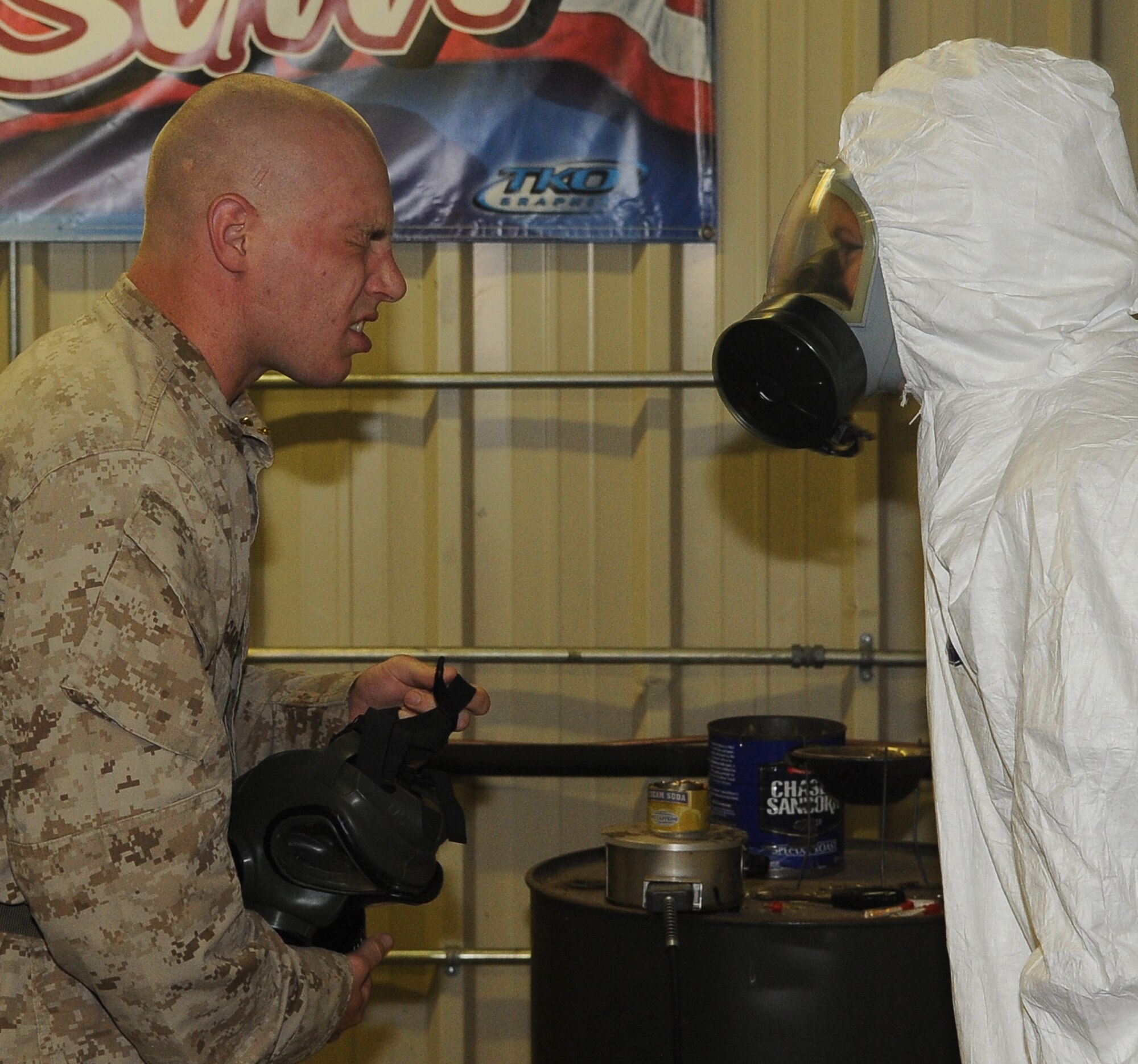 BARKSDALE AIR FORCE BASE, La -- A Marine from 1st Battalion 23rd Marines in Bossier City, leans in to hear the question being asked by Airman 1st Class Nika Kliebert, 2d Civil Engineer Squadron emergency management, during chemical warfare training Aug. 14. More than 120 Marines went through the gas chamber, provided by 2d CES, as annual training prior to a deployment. Though the mask is worn into the chamber, members were required to take it off and answer a question asked by the instructors as the tear gas was being released. (U.S. Air Force photo/Senior Airman Amber Ashcraft) (RELEASED)