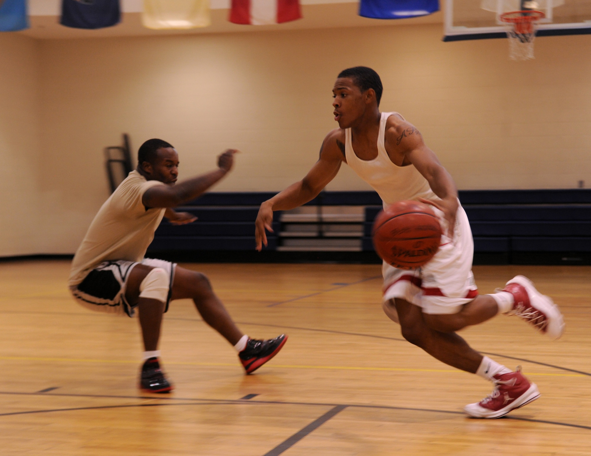 MOODY AIR FORCE BASE, Ga. --Airman Perry Arrington, 23rd Force Support Squadron food services, blows by Staff Sgt. Pernell Blaine, 823rd Security Forces Squadron, after performing a cross-over move during varsity basketball team tryouts here Aug. 18. During the tryouts, members were put through several different drills to include a one on one drill. (U.S. Air Force photo by Airman 1st Class Benjamin Wiseman/RELEASED)
