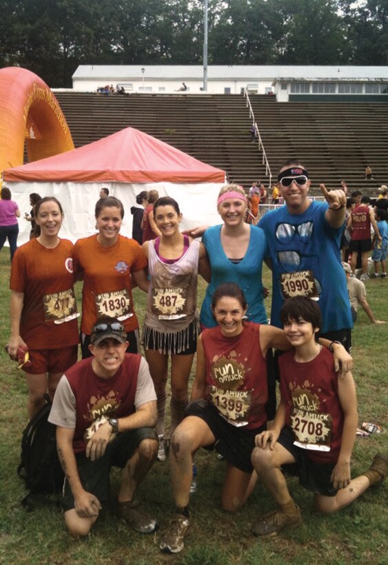 Members from the Joint Base Andrews Company Grade Officers Council take time for a victory photo at the end of the annual Run Amuck race held at Marine Corps Base Quantico on Aug. 14. More than 2200 racers attended the race which covered 3.5 miles of mixed terrain and included obstacles such as low crawling through mud under wires, climbing over walls, slaloming around hay bales, and wading through pipes filled with water. The event was just one of many the CGOC participates in to build camaraderie,  interact with the community, and support local activities in and around Joint Base Andrews. (Courtesy Photo)