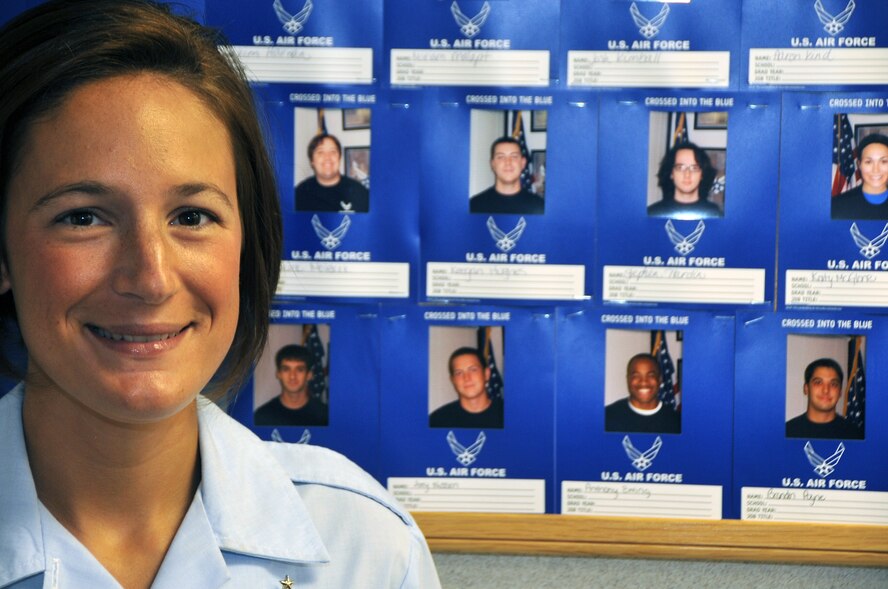 OFFUTT AIR FORCE BASE, Neb. - Staff Sgt. Elizabeth Saunders from the 343rd Recruiting Squadron stands proudly next to her "wall of pride" filled with pictures of new Airman who she assisted on their journey into the Air Force. As part of her recruiting duties, Sergeant Saunders gives presentaions to new recruits and their families and explains what the Air Force can offer them. U.S. Air Force photo by Jeff W. Gates.