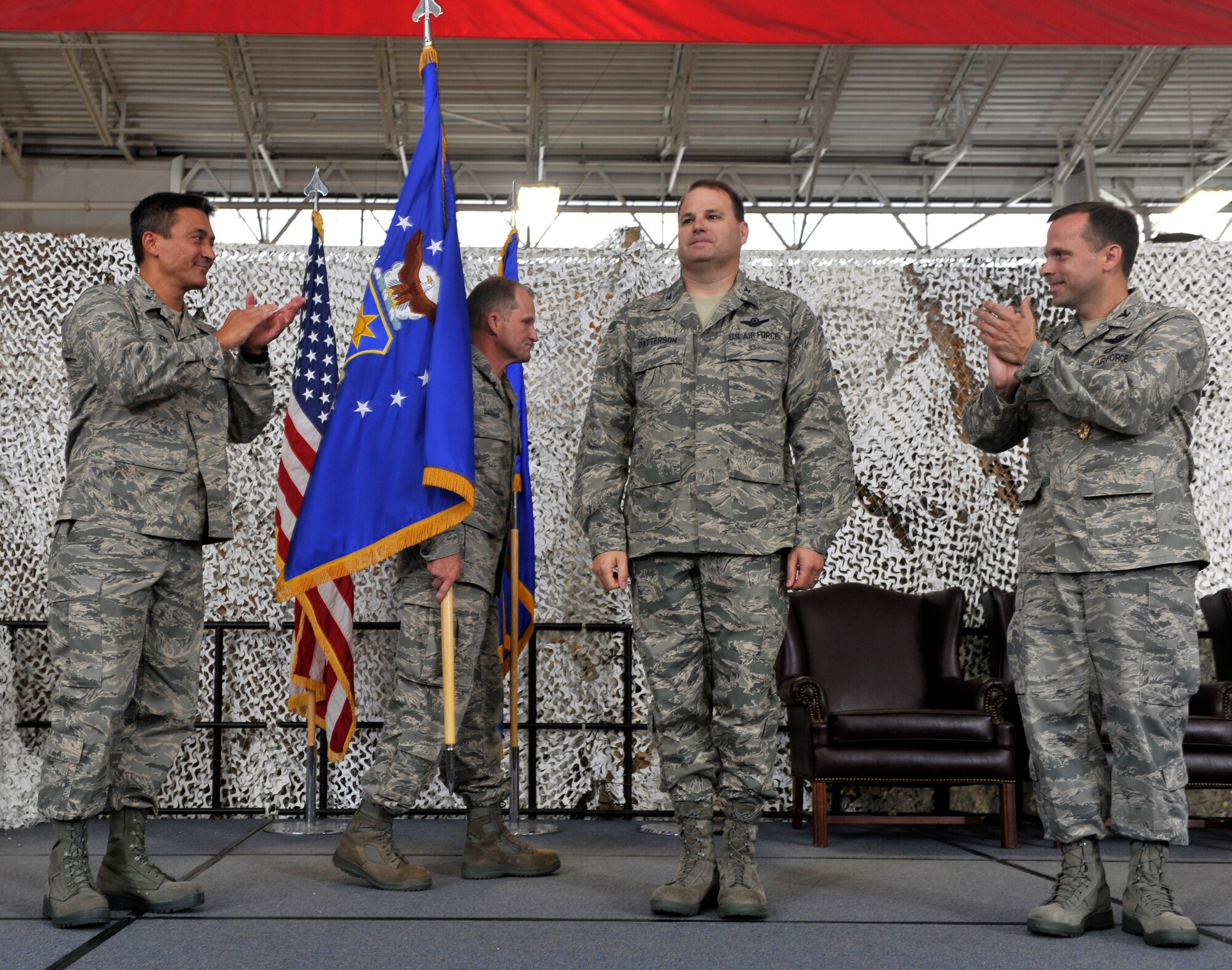 JOINT BASE MCGUIRE-DIX-LAKEHURST, N.J. - Brig. Gen. Michael Kim, 21st Expeditionary Mobility Task Force commander and Col. Brian O'Connor, previous 621st Contingency Response Wing commander applaud Col. Chris Patterson as he assumes command of the 621st CRW during a change of command ceremony here Aug. 18. Col. Chris Patterson assumed command of the unit which is responsible for training and rapidly deploying personnel to quickly open airfields in remote locations, the 621st CRW extends Air Mobility Command's ability to deploy people and equipment around the globe. (U.S. Air Force photo by Tech. Sgt. Laura K. Deckman)(released)