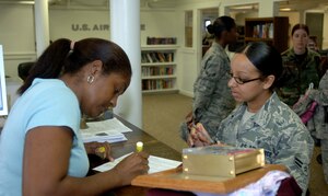 LANGLEY AIR FORCE BASE, Va. -- Caroline Munez, a full-time volunteer, assists Airman 1st Class Joseline Soto, 633d Aerospace Medicine Squadron public health technician, check out items at the newly-renovated Airman’s Attic Aug. 19. Volunteers provided more than 16,800 man hours of renovations over seven days, installing new kitchen tiles, repainting aging walls, re-carpeting and power-washing floors, and removing unneeded walls and glass. (U.S. Air Force photo/Airman 1st Class Jason J. Brown)