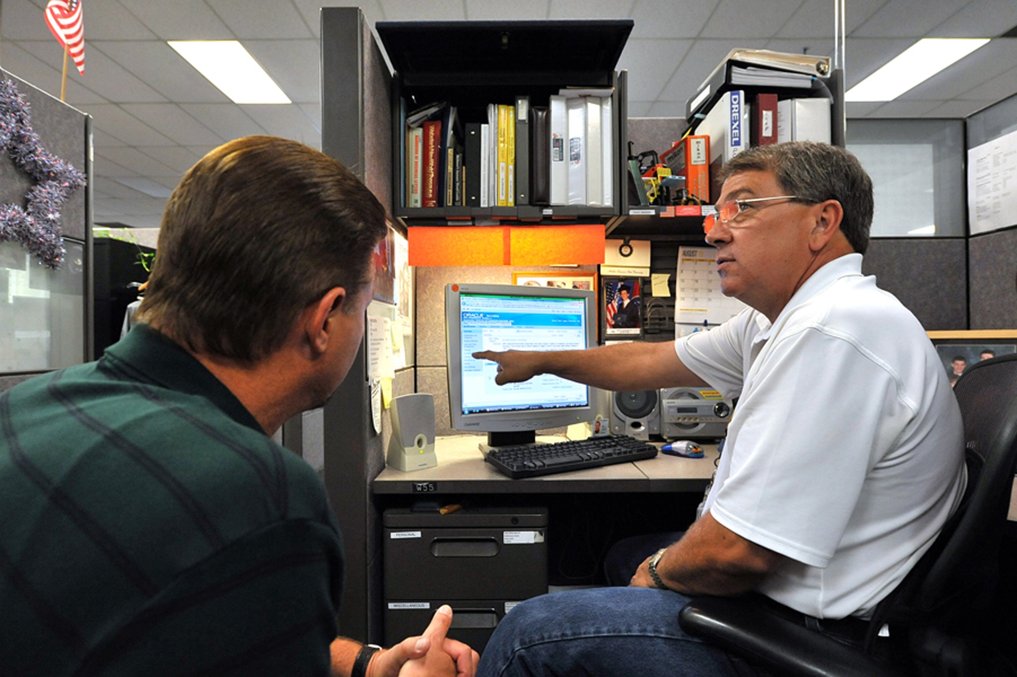 Gary Hull, equipment specialist, and a co-worker train on  Expeditionary Combat Support System software. U.S. Air Force photo by Tommie Horton