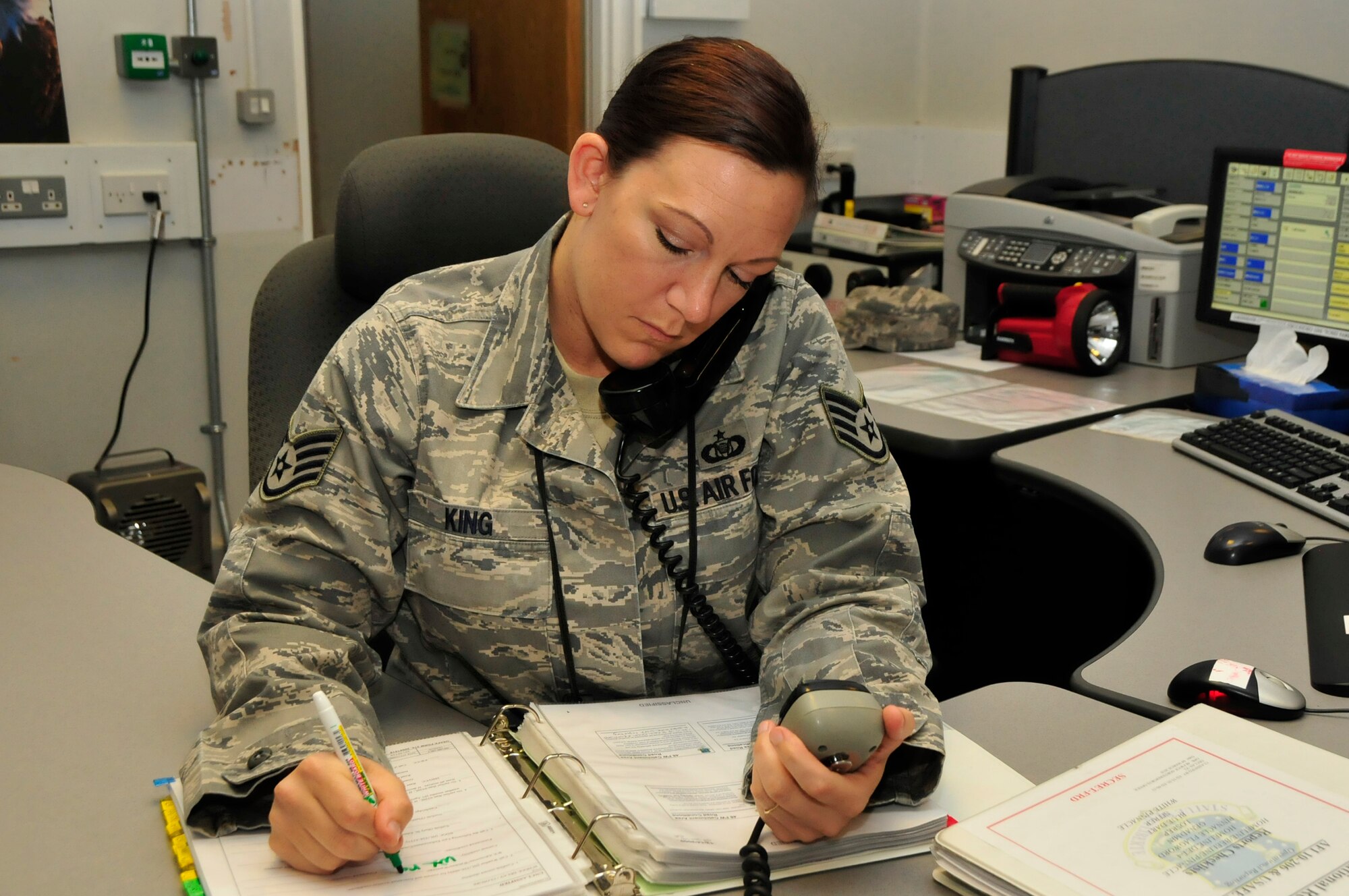 Staff Sgt. Alexis King, 48th Fighter Wing Command Post Alternate NCO In Charge of Training, records emergency calls from around base at command post at RAF Lakenheath, England Aug. 13. Sergeant King was nominated for a Liberty Spotlight because she displayed the core value of 'Excellence of All We Do. (U.S. Air Force photo/Airman 1st Class Eboni Knox)