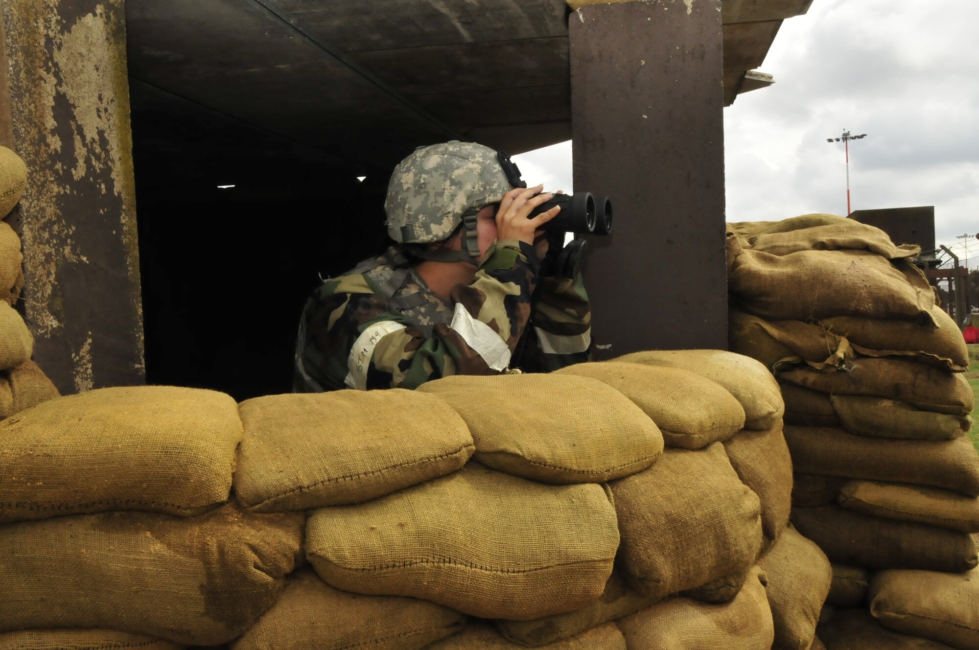 Airman 1st Class Naomi Ritz, 48th Security Forces Squadron guardsman, looks through binoculars from a defensive fighting position during an operational readiness exercise at RAF Lakenheath, England, Aug. 17. Security forces are responsible for eliminating all unauthorized entries into Base X. (U.S. Air Force photo/Airman 1st Class Eboni Knox)
