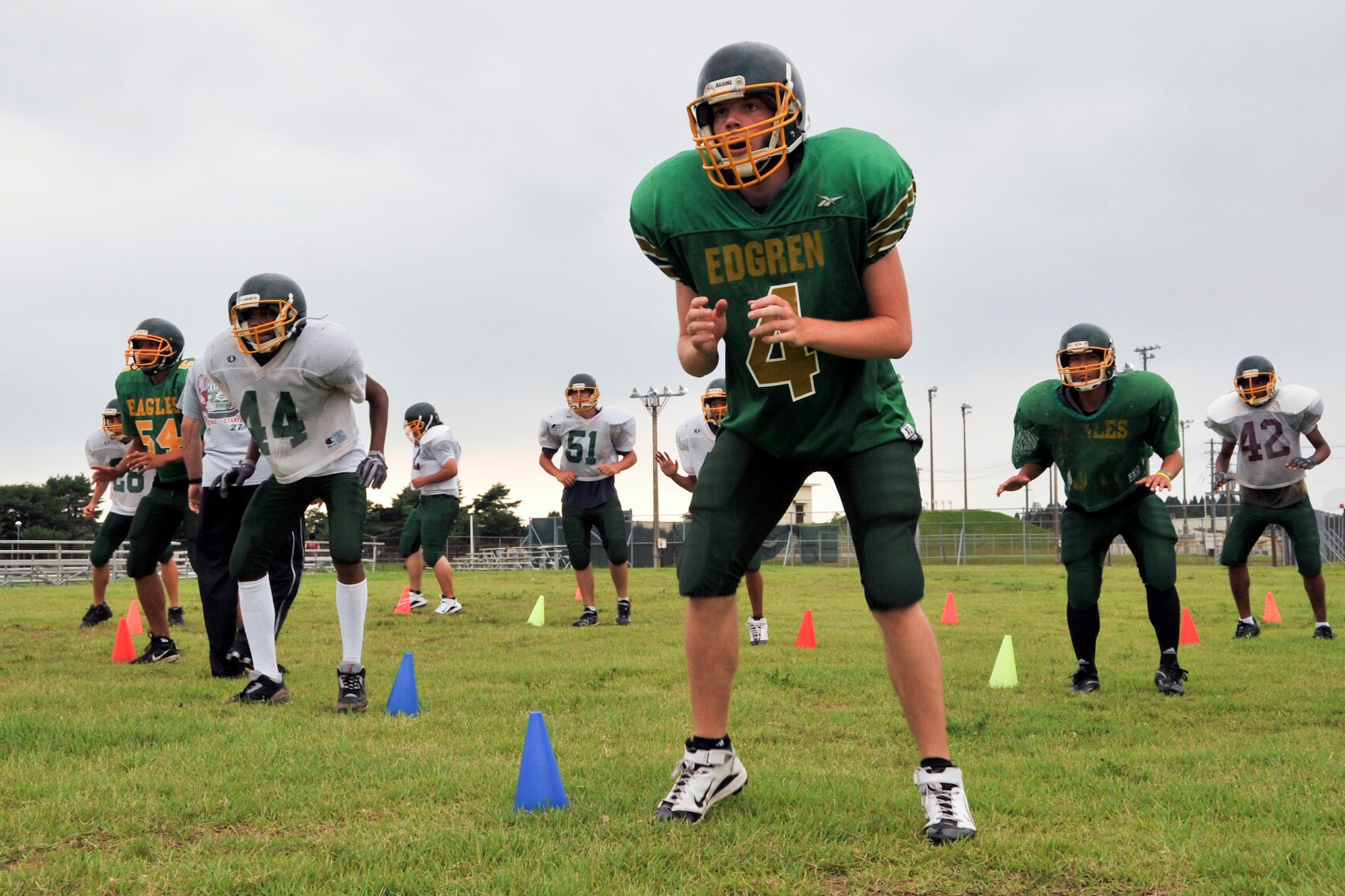 MISAWA AIR BASE, Japan -- Edgren Eagles high school football players gear up for their upcoming season. Jack Koch (center), takes part in "first step," which is moving to different postions diagonally, left to right, while moving from the back to the front of the field. The eagles are in their second week of two-a-day practiecs. (U.S. Air Force photo/Tech. Sgt. Russell McBride)