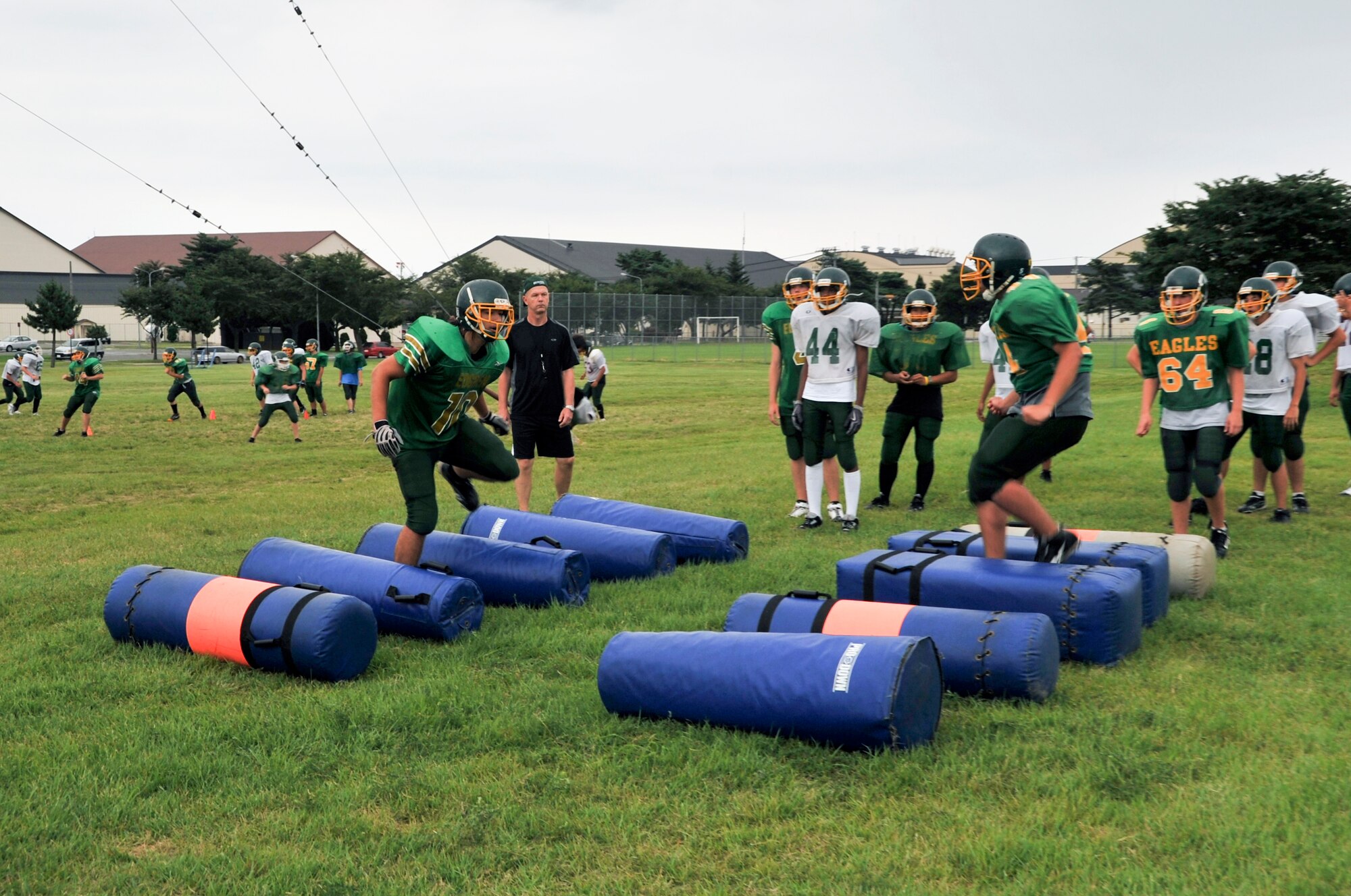 MISAWA AIR BASE, Japan -- The Edgren Eagles high school football team gear up for their upcoming season. Player Sayer Austin (left) performs coordination drills , high-stepping through pads on the ground. Practice also includes offensive plays, kicking, punting, offence, defence line drills and tackling drills. (U.S. Air Force photo/Tech. Sgt. Russell McBride)