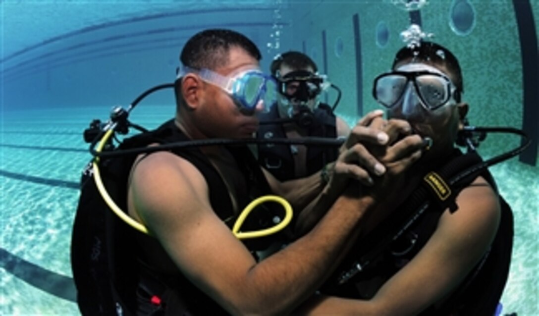 Panamanian diver Cpl. Edwin Sanchez (left) shares his regulator with Cpl. Jamie Berchi (right) in Panama City, Panama, on Aug. 17, 2010.  U.S. Navy divers assigned to Company 2-6, Mobile Diving and Salvage Unit 2 conducted SCUBA familiarization prior to joint operations out at sea.  Mobile Diving and Salvage Unit 2 participated in Navy Diver - Southern Partnership Station, a multinational partnership engagement designed to increase interoperability and partner nation capacity through diving operations.  