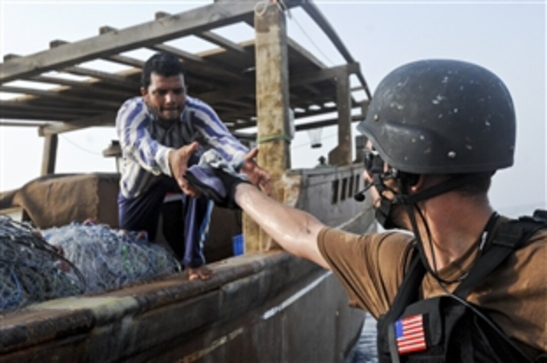 U.S. Navy Petty Officer 2nd Class David McGhee hands supplies to a fisherman in the Red Sea, Aug. 9, 2010. Princeton is part of Combined Task Force 151, a multinational task force established in 2009 to conduct counter-piracy operations in the Gulf of Aden. McGhee is a sonar technician assigned to the visit, board, search and seizure team aboard the guided-missile cruiser USS Princeton.
