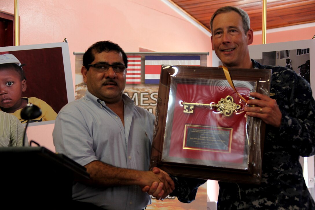 Navy Capt. Thomas N. Negus, commodore of Operation Continuing Promise 2010, shakes hands with Eduardo Barboza, mayor of Limon, Costa Rica, after receiving a key to Limon, Aug. 21, 2010, during the opening ceremony of CP10. Marines, sailors and USS Iwo Jima personnel will conduct medical, dental, veterinary and engineering services to the Limon community as part of the CP10 mission. CP10 is currently deployed to the Caribbean, Central and South America to provide humanitarian civic assistance to eight nations.