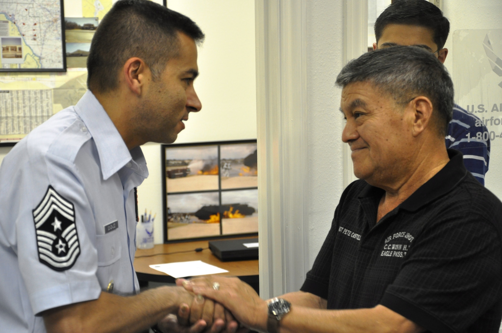 LAUGHLIN AIR FORCE BASE, Texas – Command Chief Master Sgt. Ruben Gonzalez, Air Force Recruiting Service command chief, presents Master Sgt. (ret.) Pete Castillo, who recruited him into the Air Force in 1985, with his coin Aug. 19 in Del Rio. Chief Gonzalez, who is from Eagle Pass and recruited into the Air Force out of Del Rio, chose to begin his world-wide tour of AF recruiting stations with Del Rio. (U.S. Air Force photo by Airman 1st Class Blake Mize)